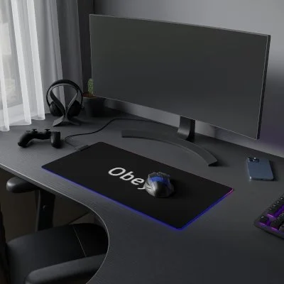 Gaming setup with large monitor, gaming headset, game controller, mouse, and keyboard on a black desk.
