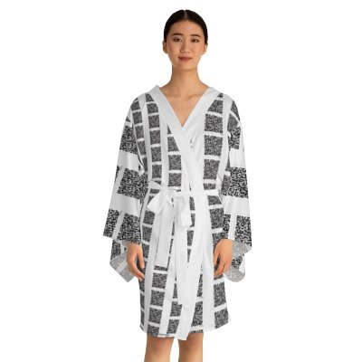 A woman wearing a black and white patterned kimono-style robe with a matching belt.