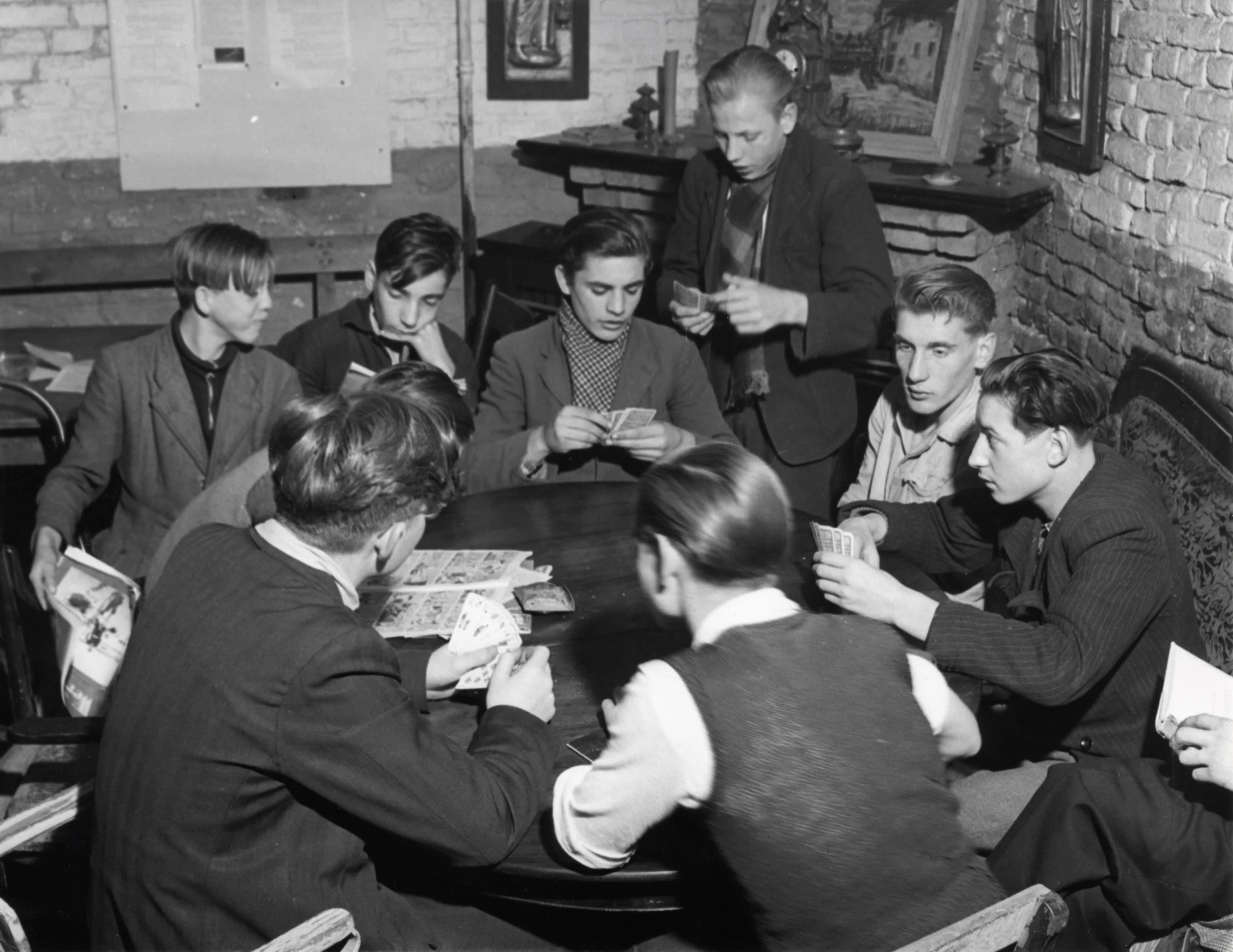 Kaartende jongeren in buurthuis pater Castorius 1951 [NA]