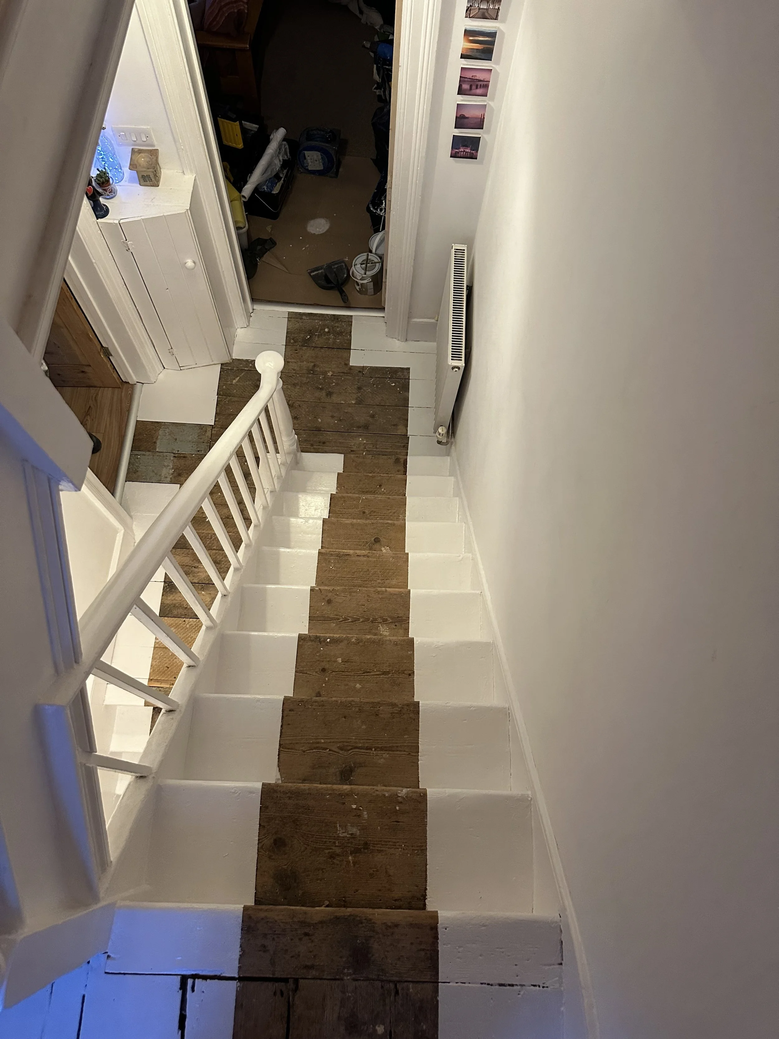 Stairs painted in advance of a carpet runner, using Bradite floor paint in white. Wooden stair treads needed repairing and filling in places, as well as old nails and staples being removed.