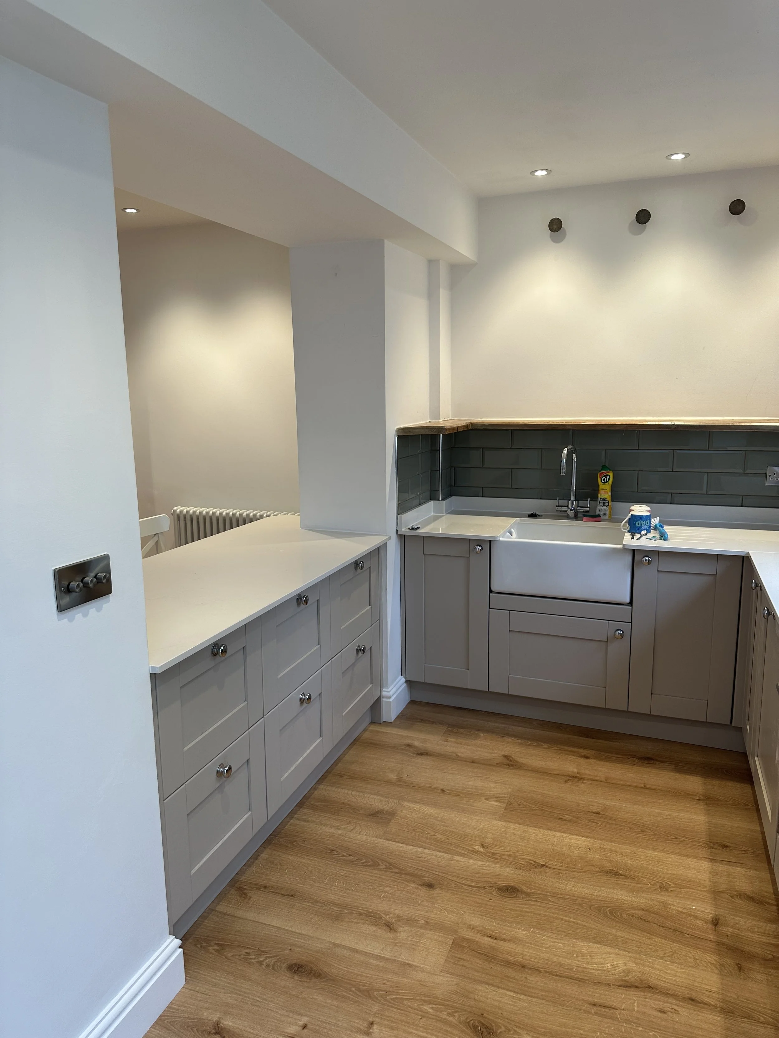 Basement renovation with ceilings and woodwork in white for a landlord's renovation. The walls, hatch style island and woodwork were all part of an extensive renovation in a 5 bedroom townhouse in East Brighton. 