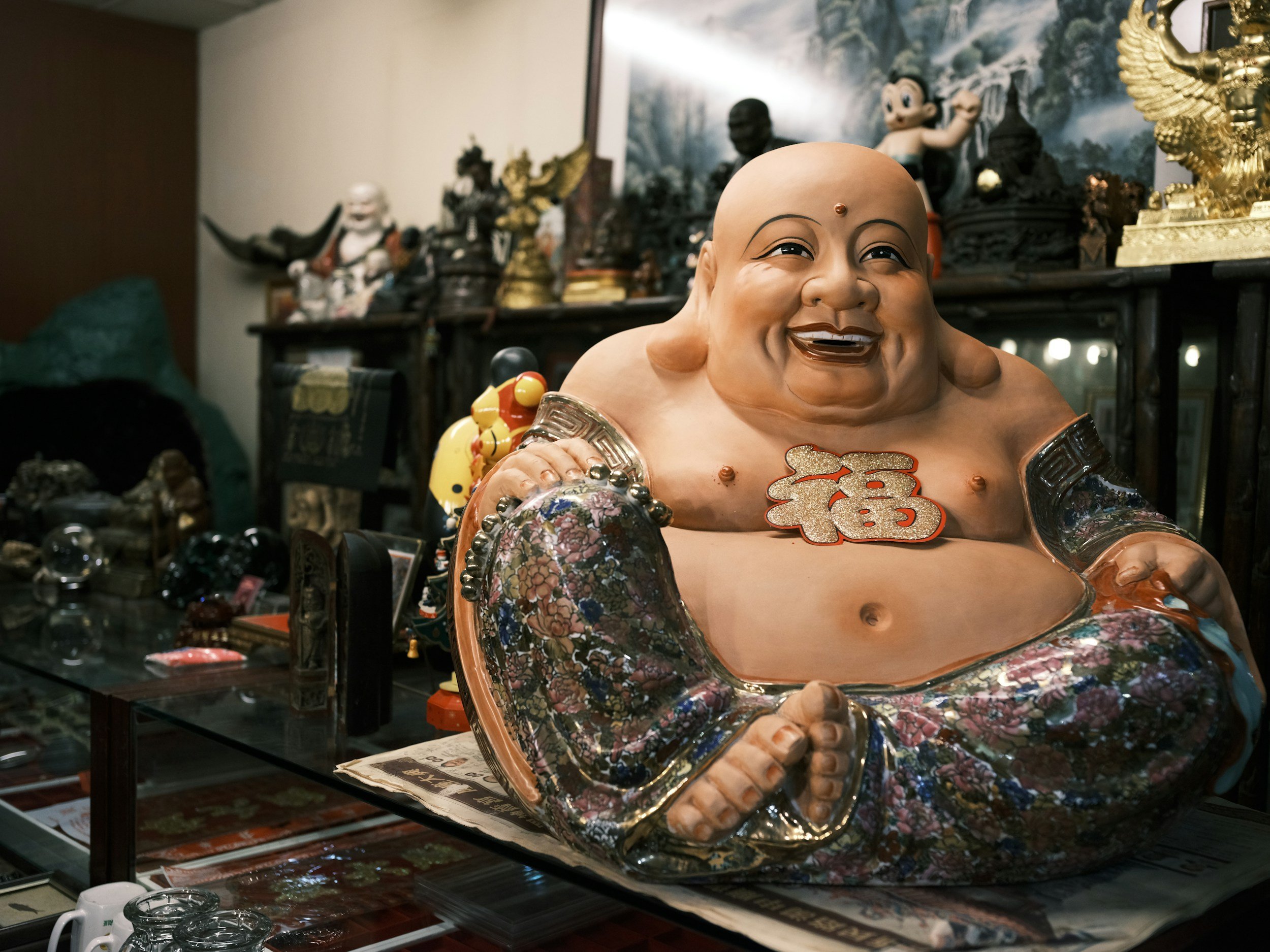 Ein Buddha mit dickem Bauch schaut zufrieden in die Ferne.