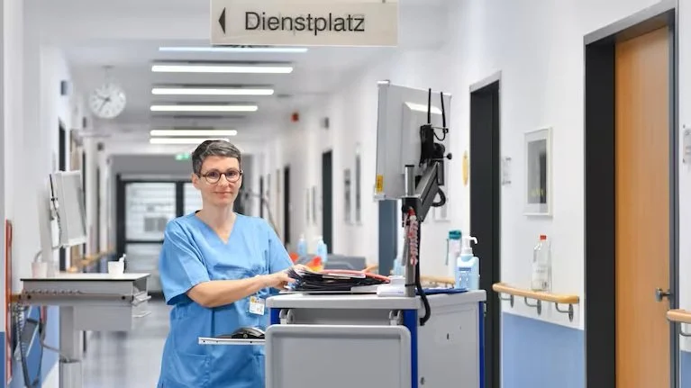 Krankenpflegerin Gitte Raczynski steht während ihrer Frühschicht auf dem Gang der Onkologie-Station.