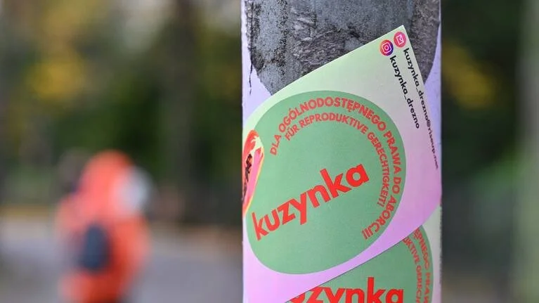 Ein Sticker an einem Mast macht auf die Arbeit von "Kuzynka Drezno" aufmerksam.
