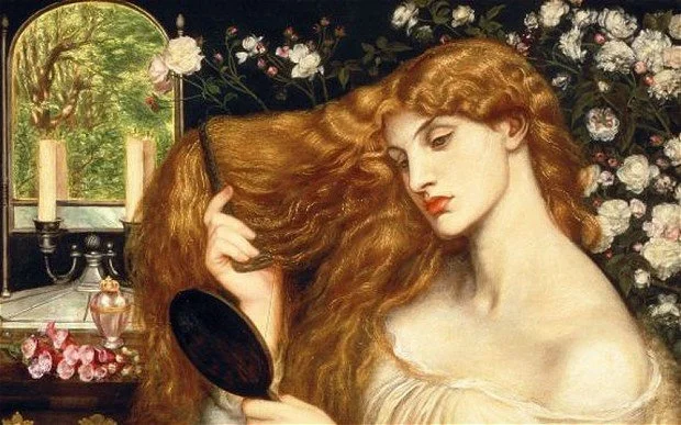 A woman with long, flowing red hair looking into a hand mirror, surrounded by flowers and candles in a vintage setting.