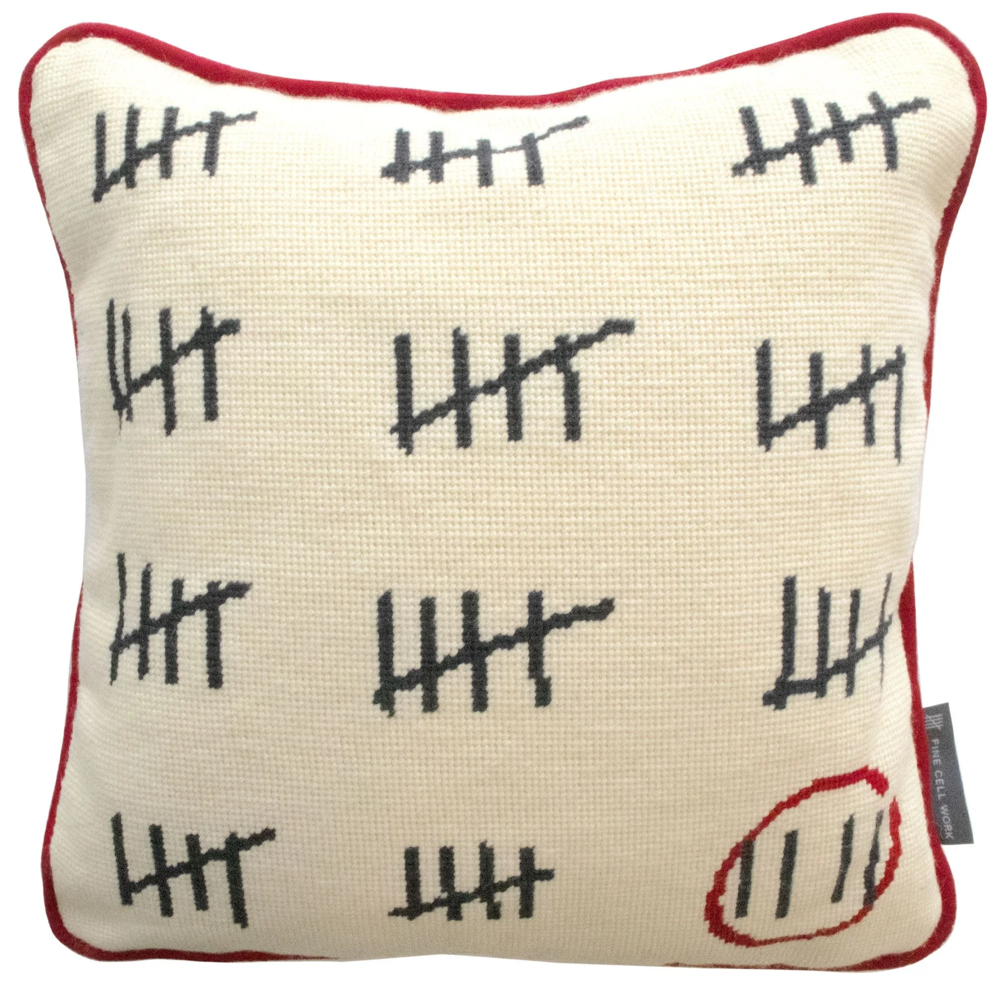 A plush pillow with tally marks embroidered on it, outlined with red piping.