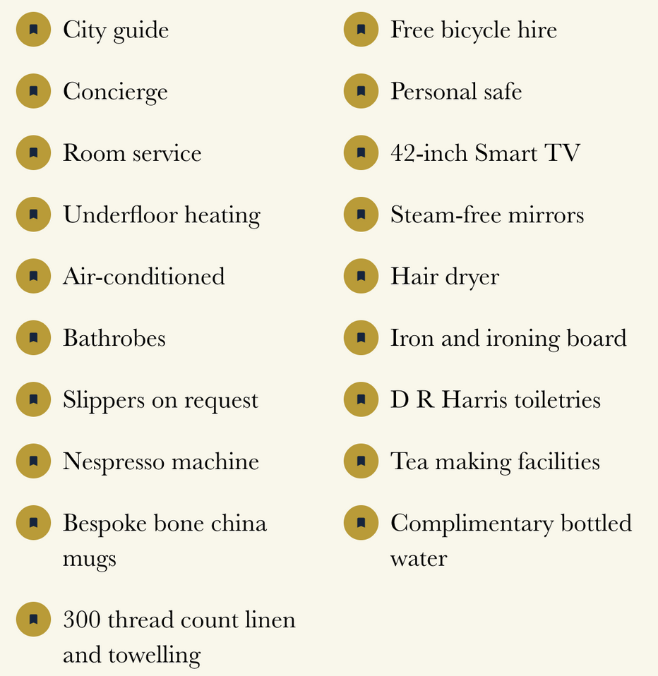 A list of hotel amenities and services, including city guide, concierge, room service, underfloor heating, air-conditioned rooms, bathrobes, slippers, Nespresso machine, bone china mugs, linen and toweling, free bicycle hire, personal safe, 42-inch smart TV, steam-free mirrors, hair dryer, iron and ironing board, toiletries, tea making facilities, complimentary bottled water.