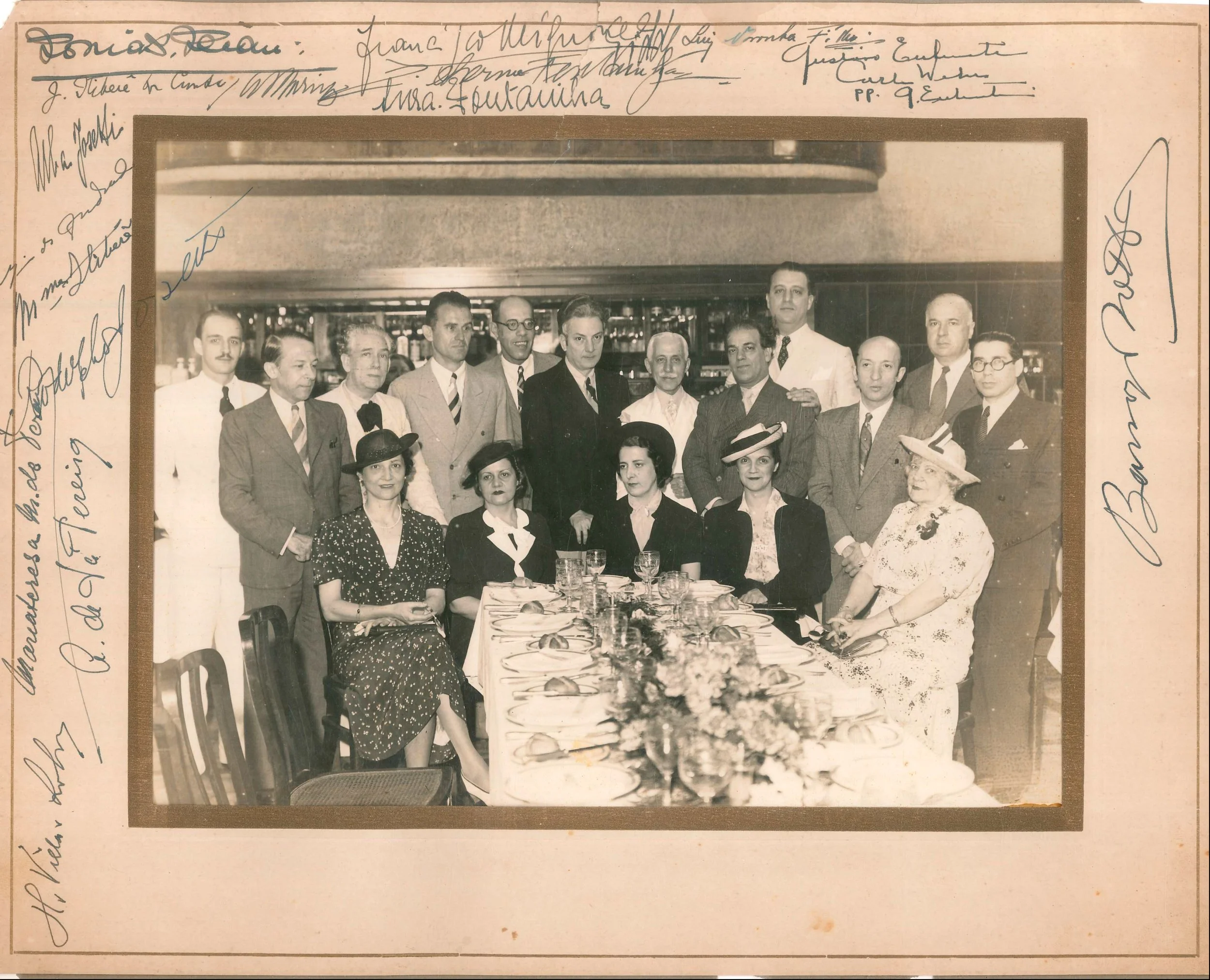 Liddy sentada à esquerda (vestido preto com pontos brancos) e Mário de Andrade (no meio dos homens em pé, de óculos) em almoço comemorativo na década de 1930.