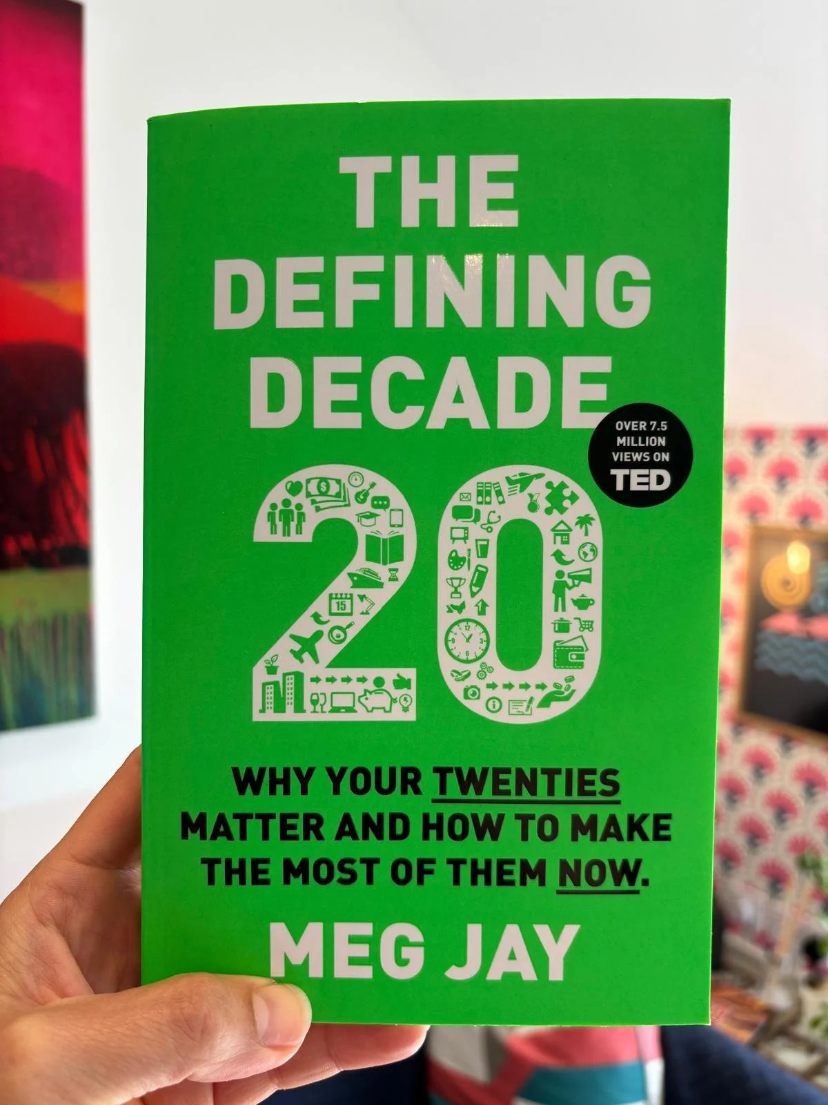 Photo of a hand holding up the book The Defining Decade:20 by Meg Jay