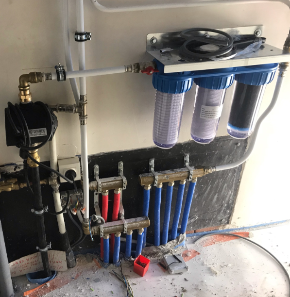 Waterfilter installatie met rode en blauwe leidingen voor drinkwater.
