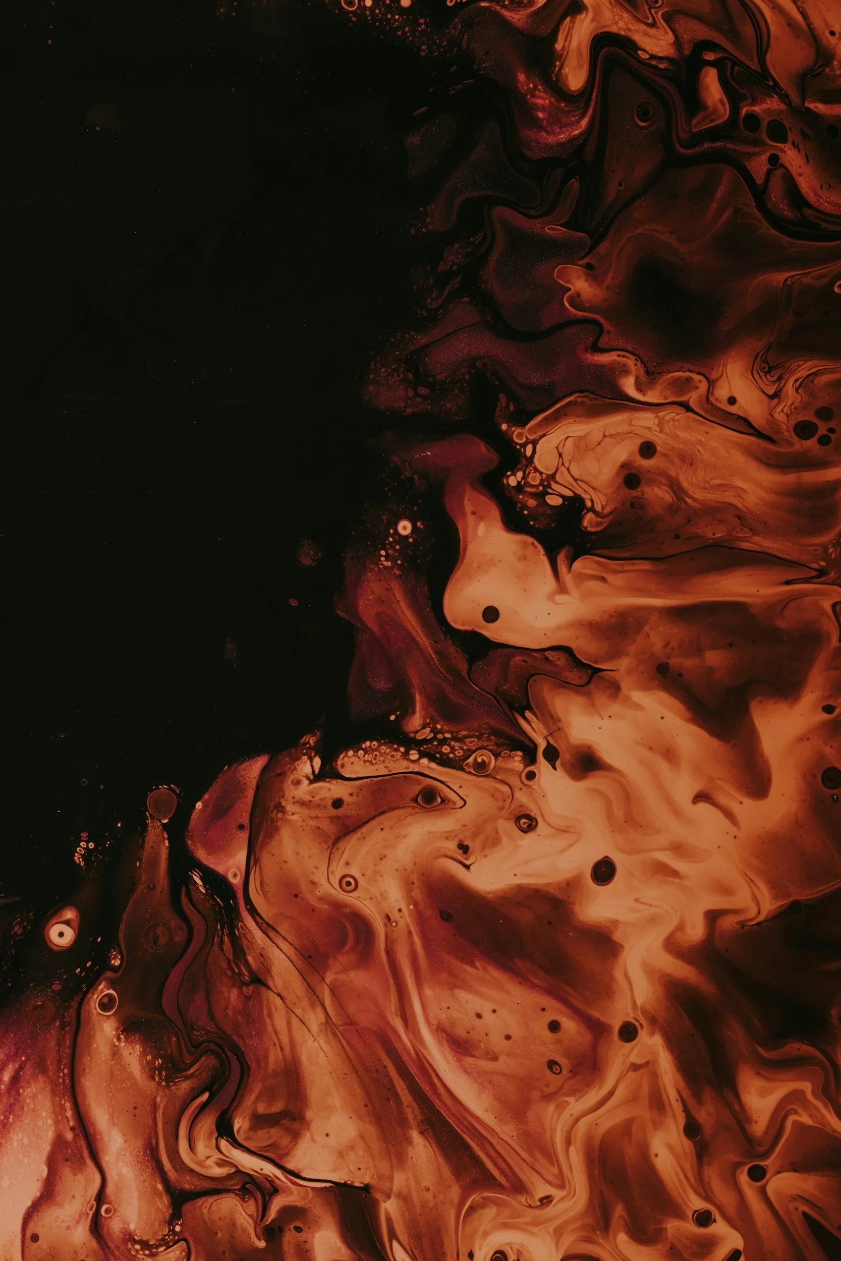 Abstract swirling pattern of red, orange, black, and cream colors blending together in a fluid, marbled design.