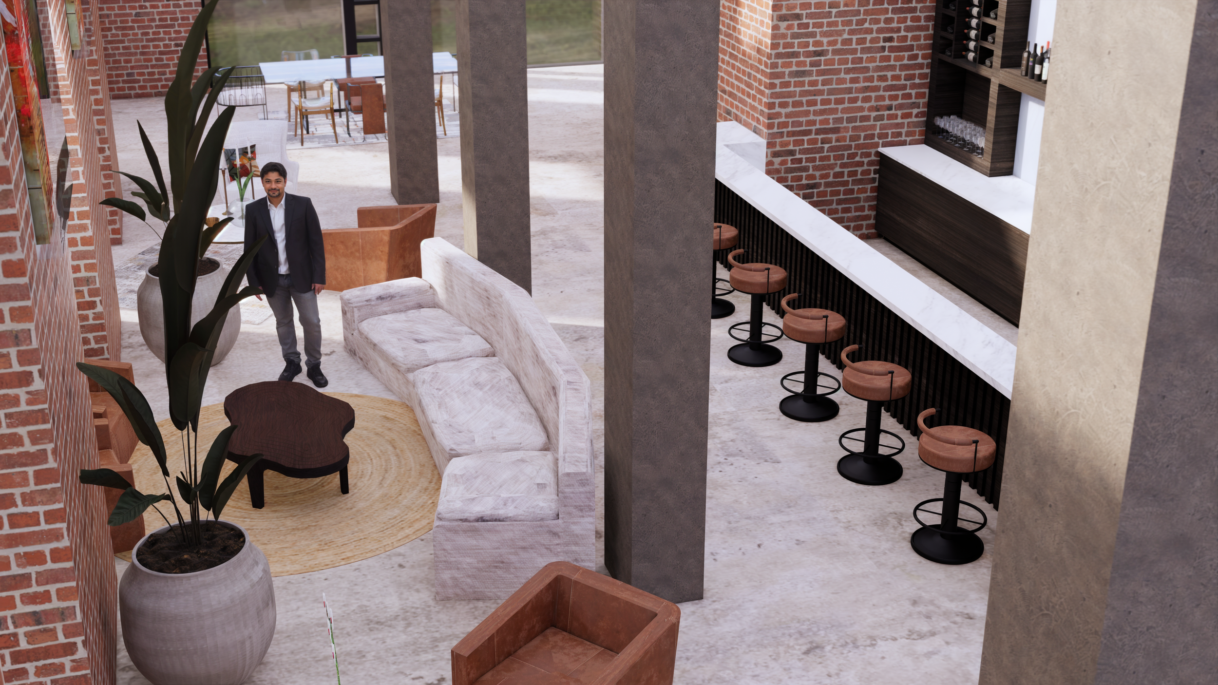 Interior of a modern bar or lounge with exposed brick walls, a large potted plant, a light-colored sofa with matching cushions, a small dark wooden coffee table, a row of bar stools with tan seats along a white marble bar counter, and a man in a suit standing near the sofa.