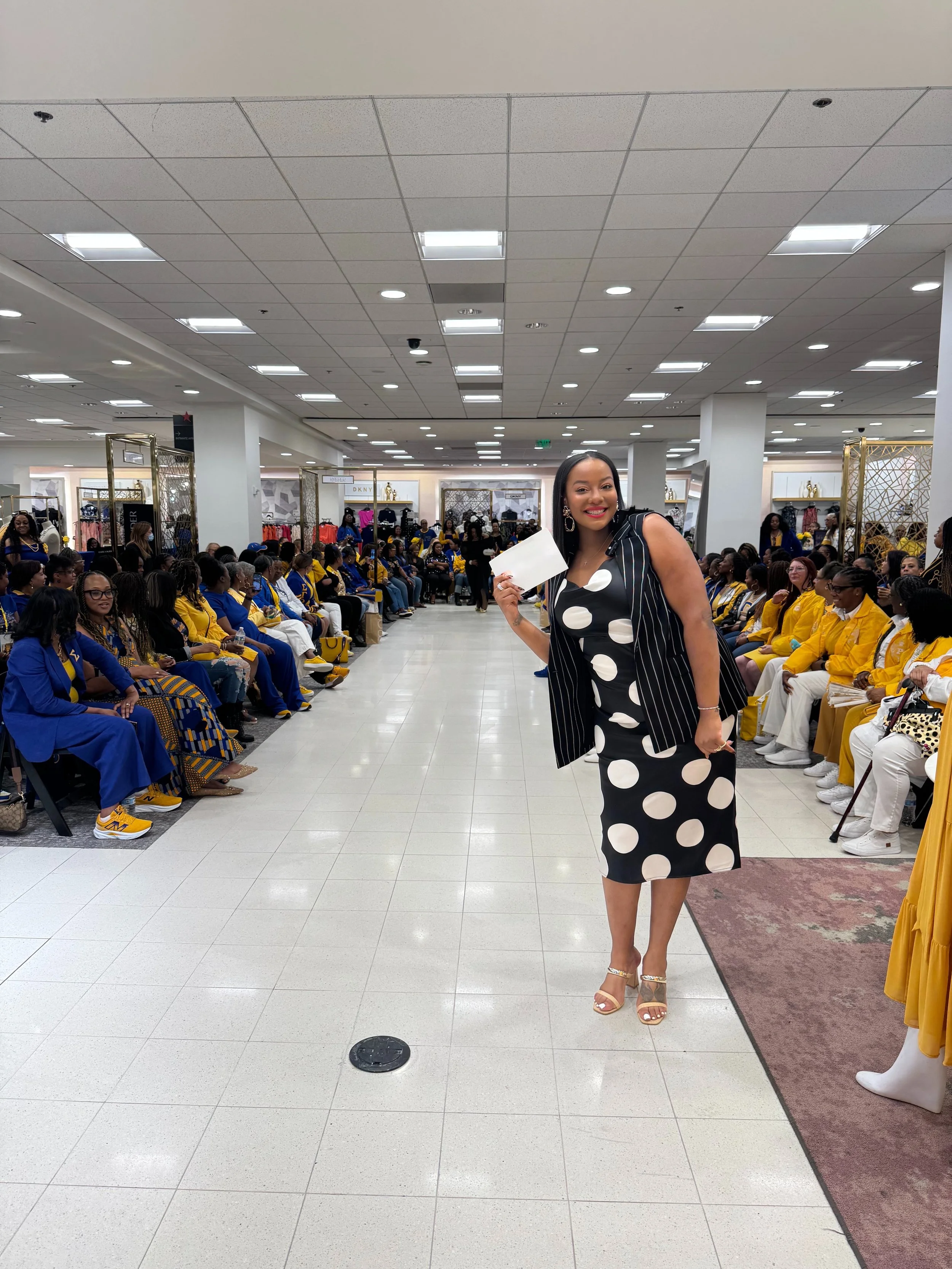Tee Thompson speaking to an audience during a Suit Up for Success event at Macy's Union Square with the Western Region Sigma Gamma Rho in attendance.
