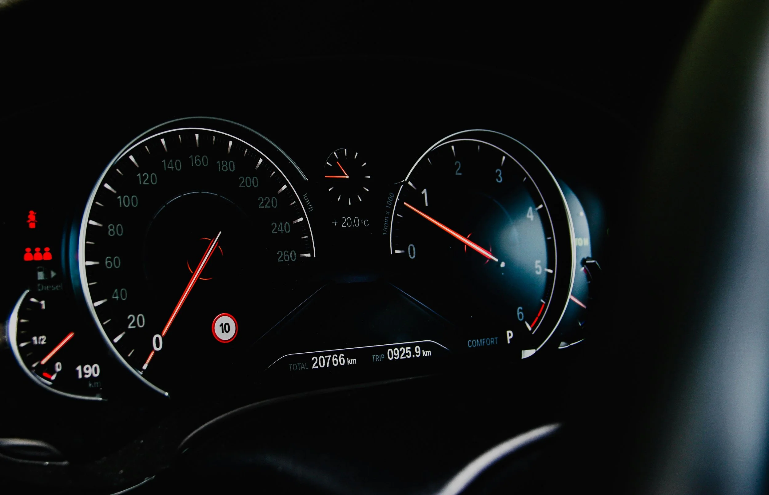 Close-up of a car dashboard showing speedometer, tachometer, and warning lights.