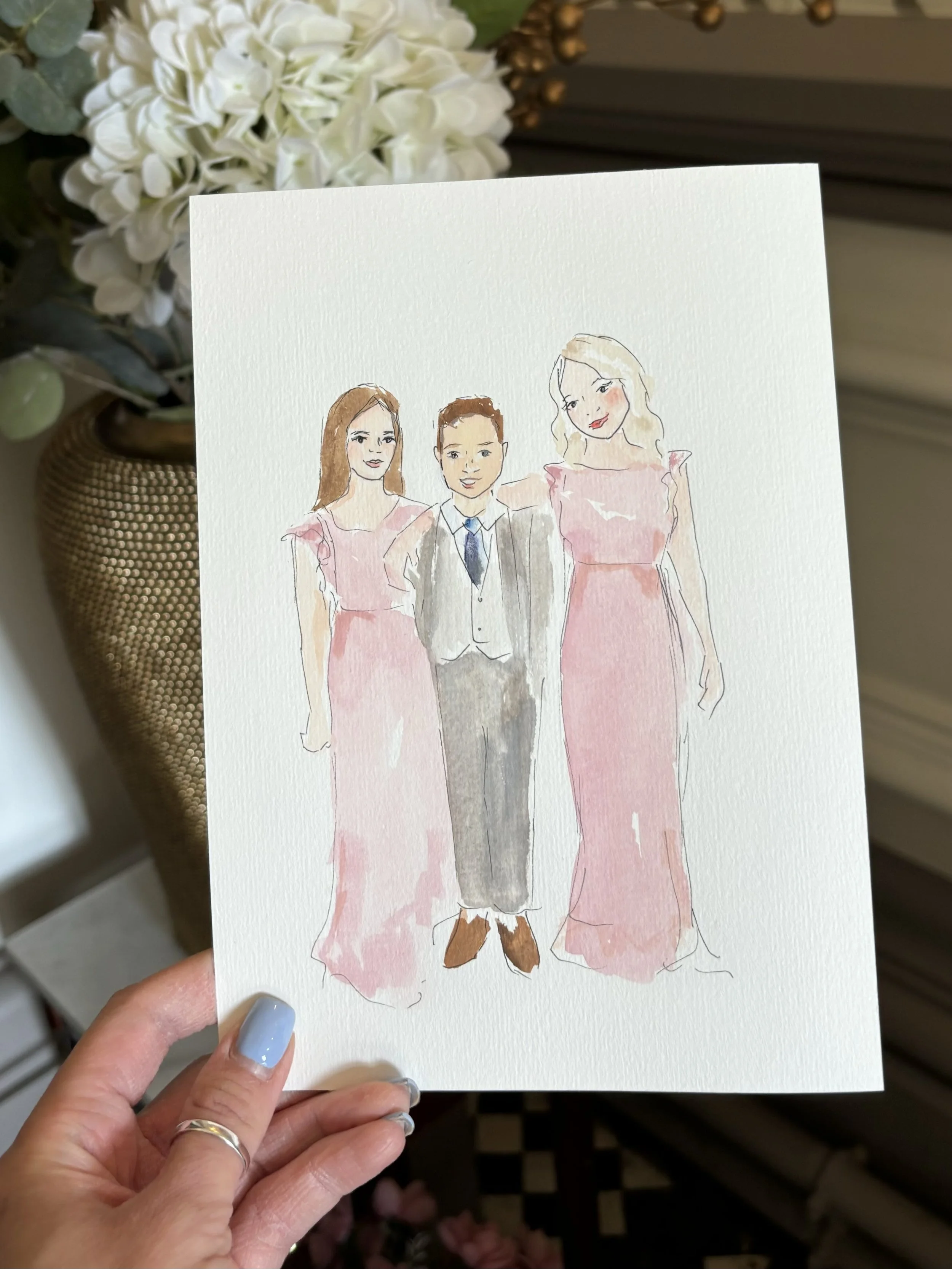 A watercolor illustration of a man in a gray suit with a blue tie, flanked by two women in pink dresses, standing together with arm around each other.
