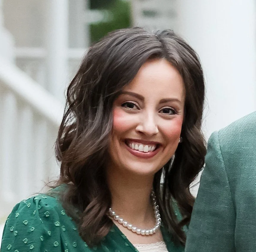 Victoria Kiker  in green dress and pearl necklace smiling indoors during a lifestyle portrait session in Charlotte NC