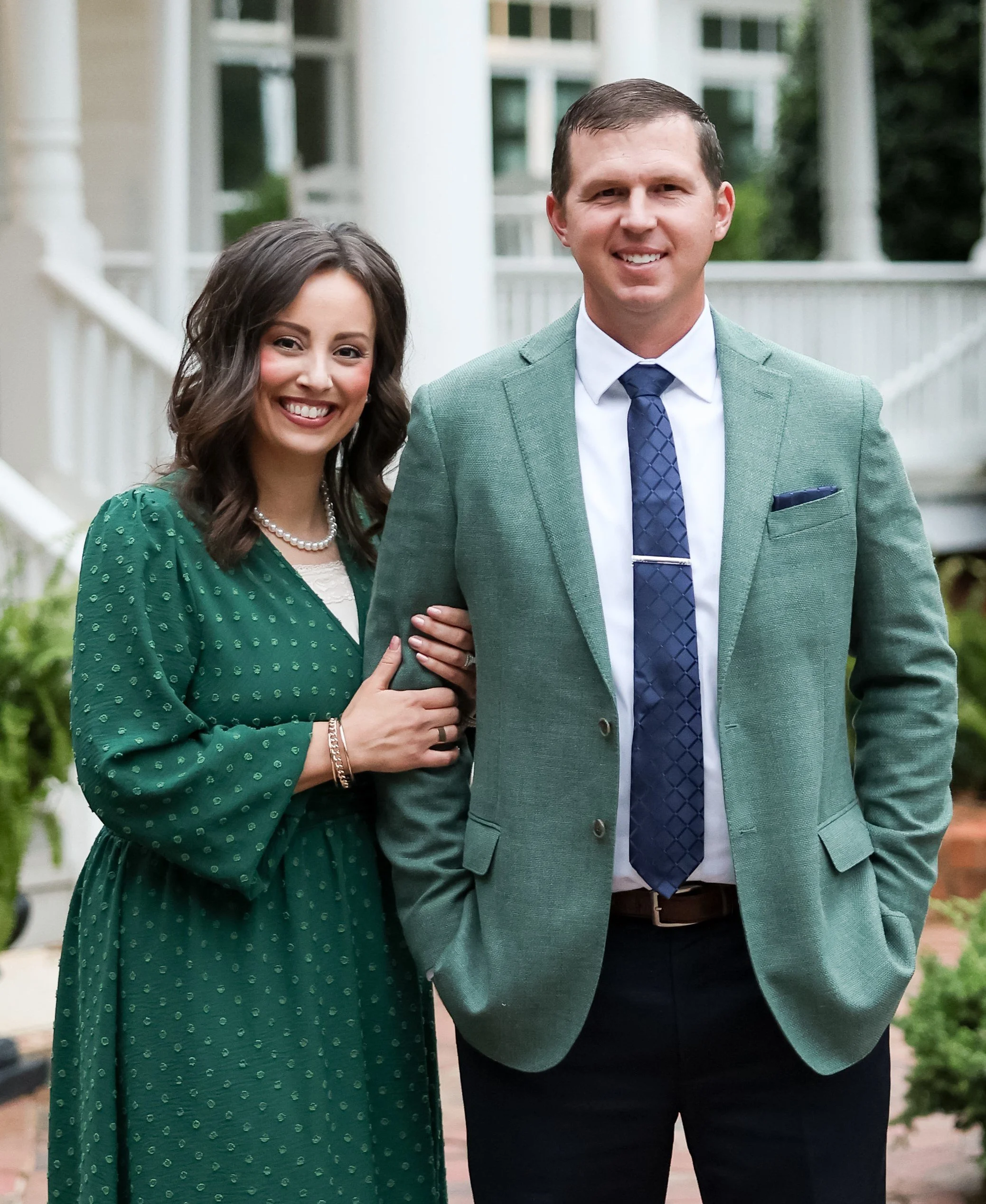 Randy and Victoria Kiker  standing together outdoors in front of landscaped greenery and fresh sod lawn in Concord NC