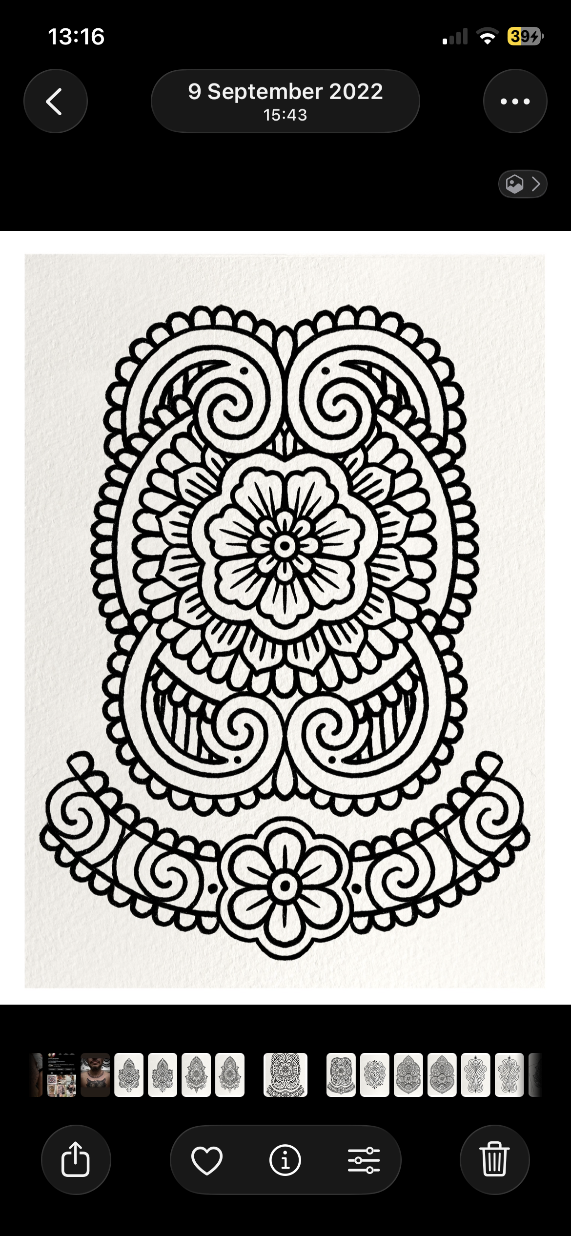 Black and white intricate floral mandala pattern with symmetrical swirls and petal designs.