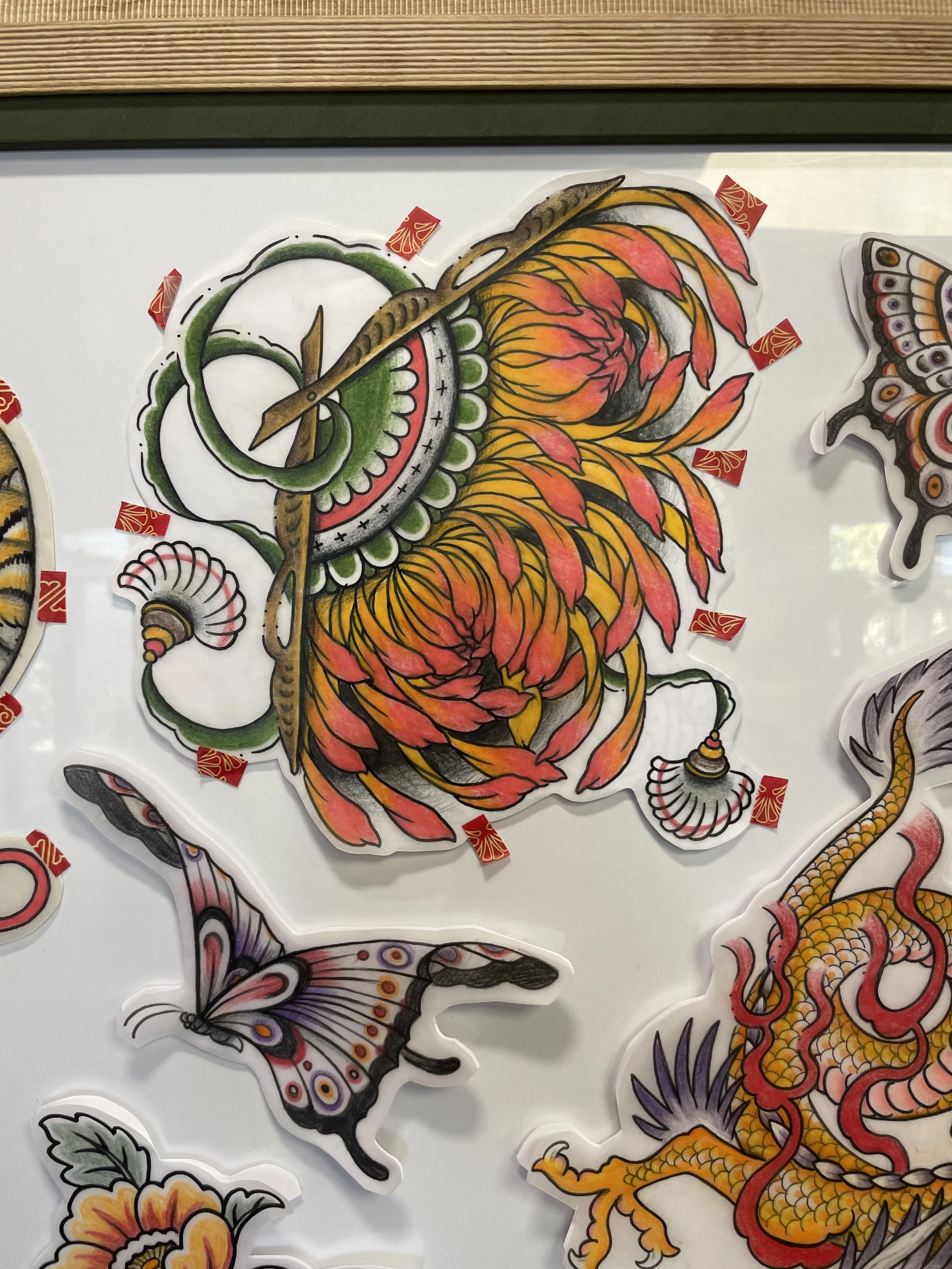 Colorful sticker art of a traditional Chinese dragon with an orange and yellow body and a green and white face, decorated with intricate patterns and bold lines.