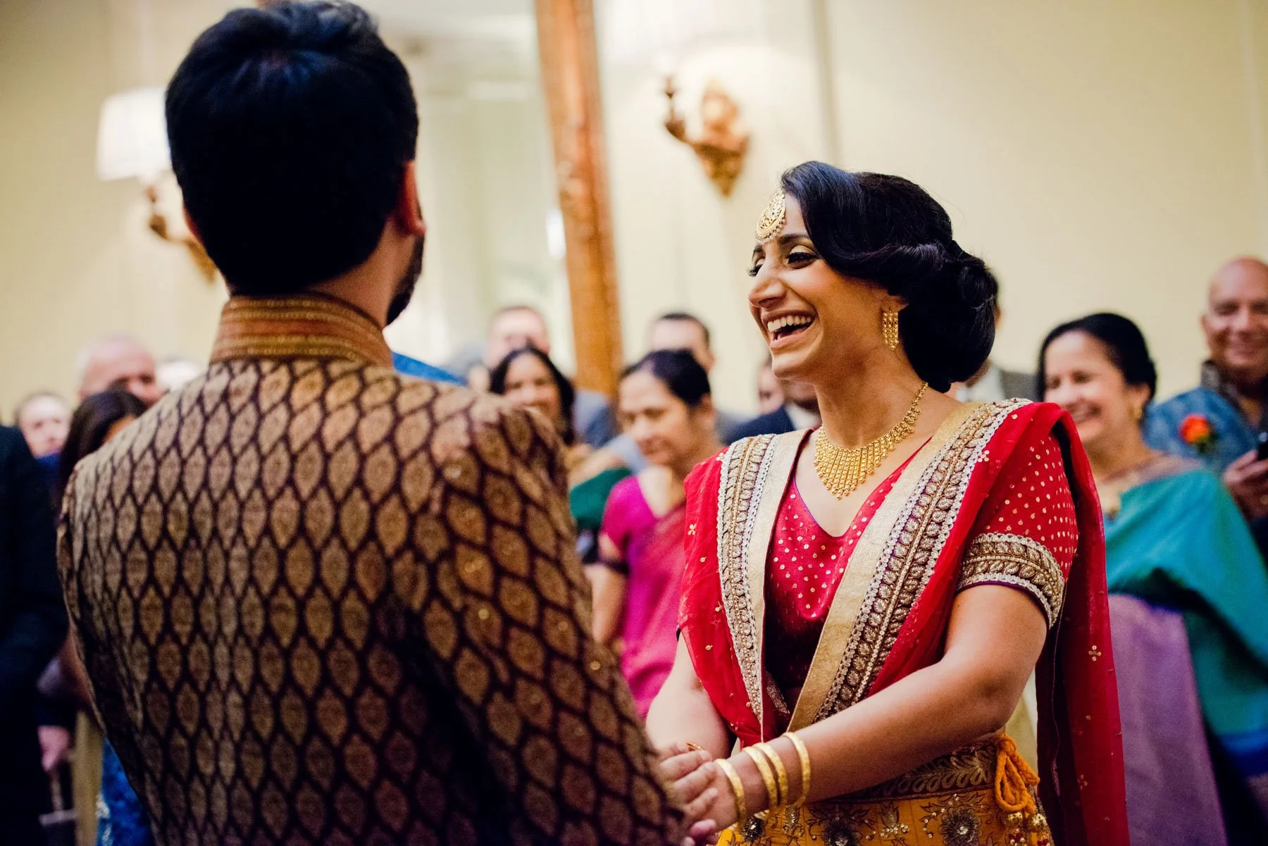 Bride and groom laughing during their Asian wedding ceremony at Hedsor House in Windsor
