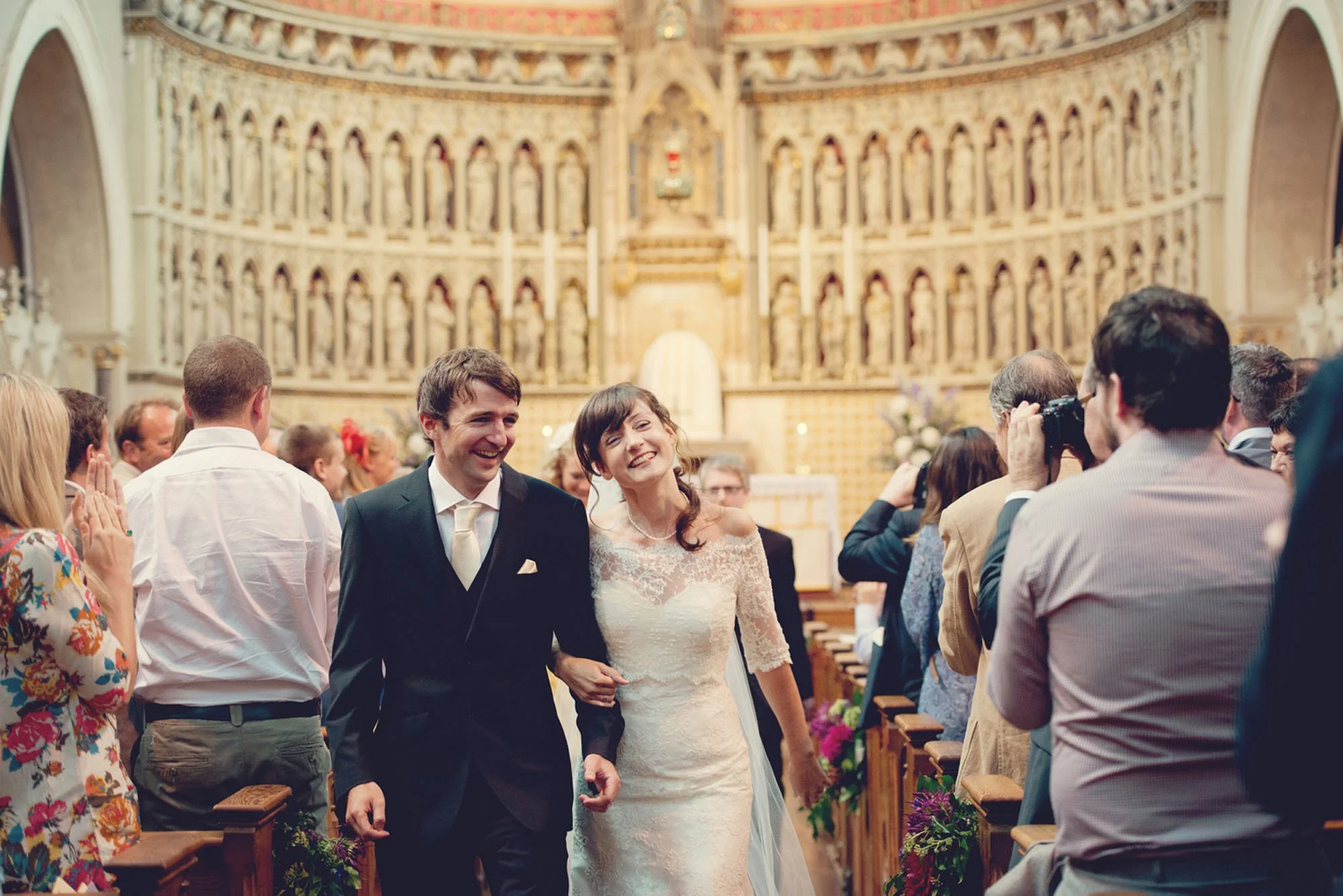 Bride and groom laughing as they leave their wedding at the Oxford Oratory Church