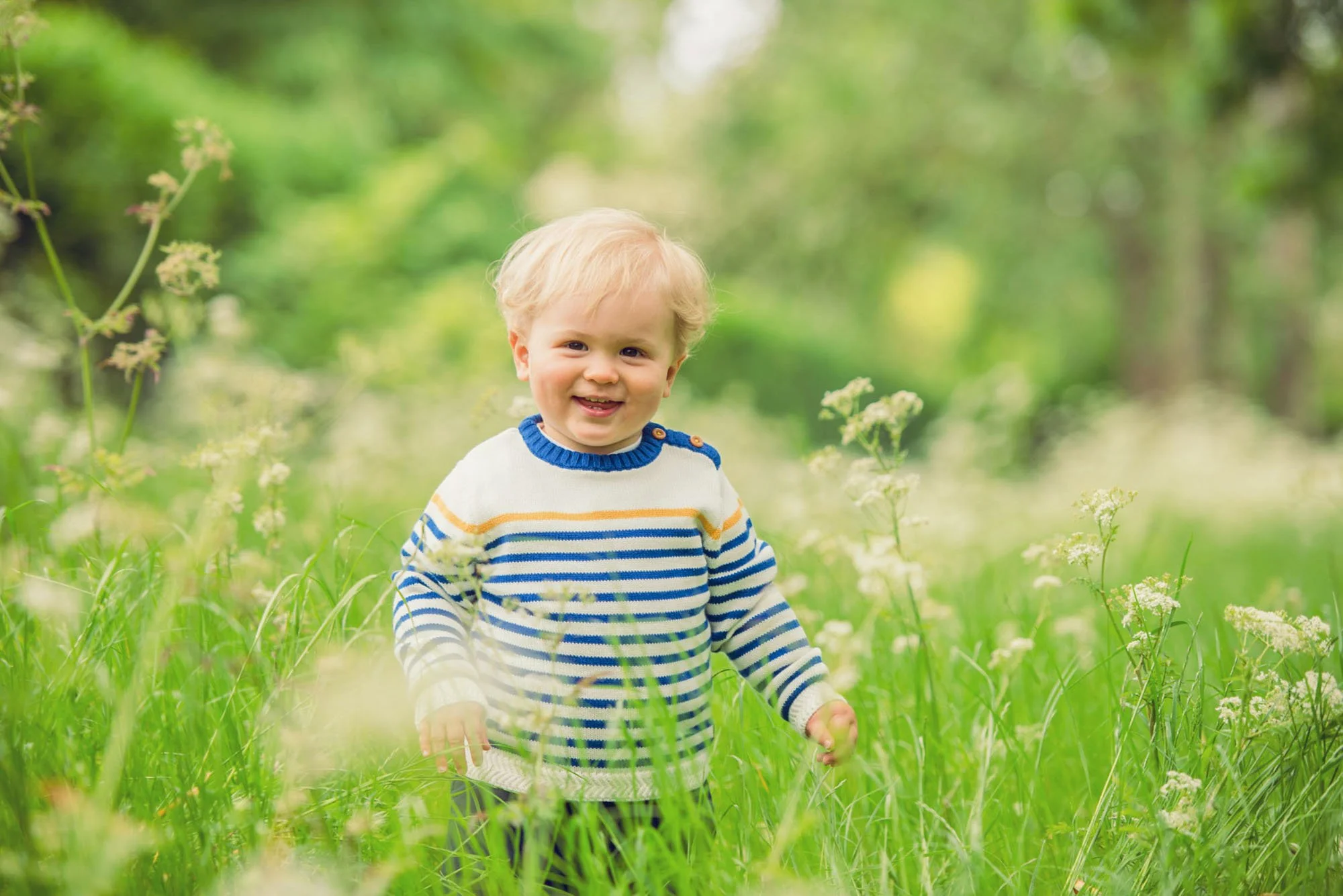 Little boy smiles at the camera during a family photoshoot in Regent's Park London 