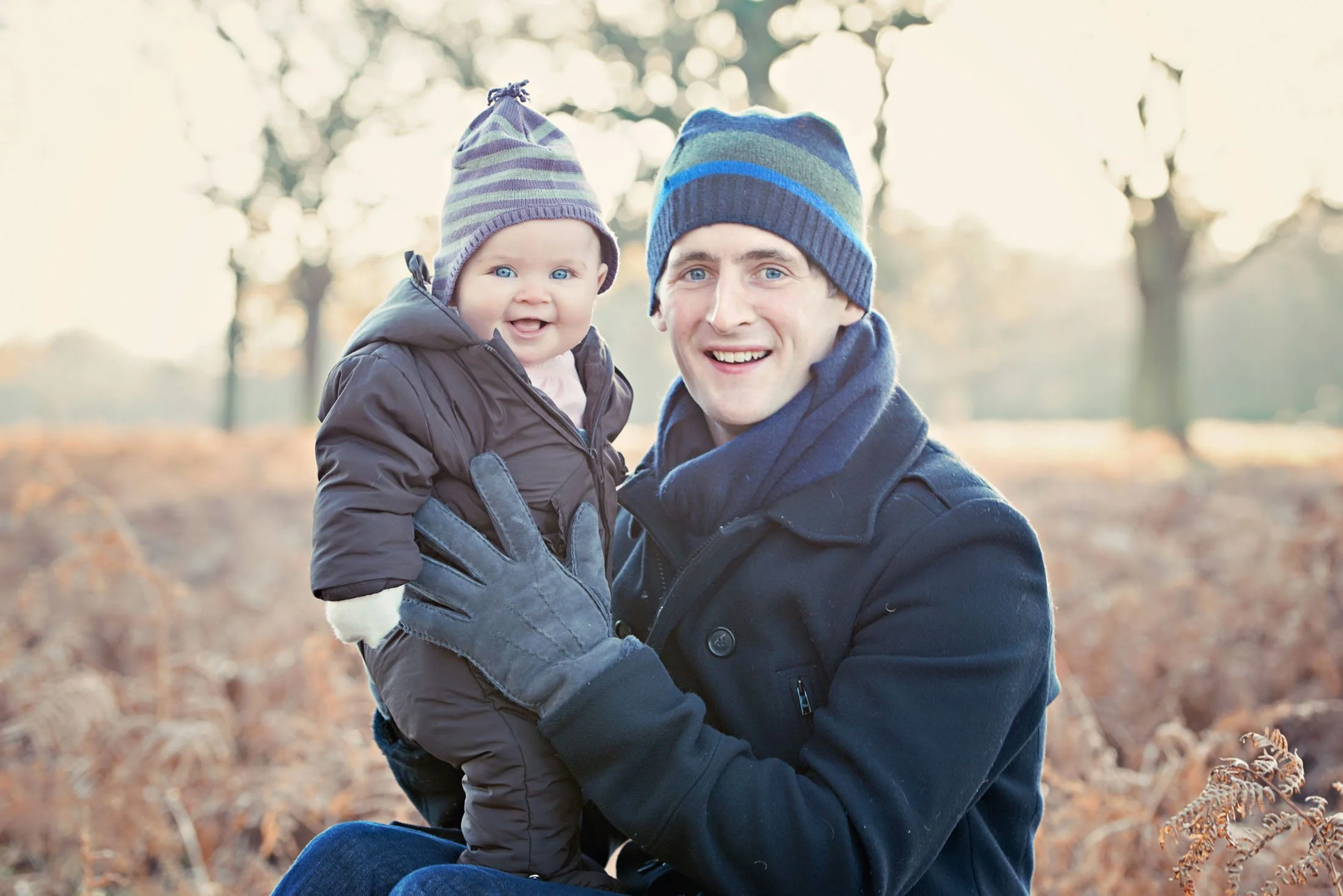 Father and baby in Richmond Park in the winter, with beautiful natural light and a frosty backdrop