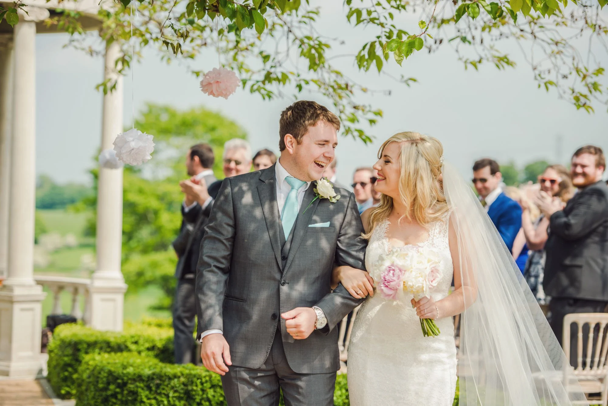 Bride and groom laugh after their outdoor wedding ceremony at Froyle Park in Hampshire