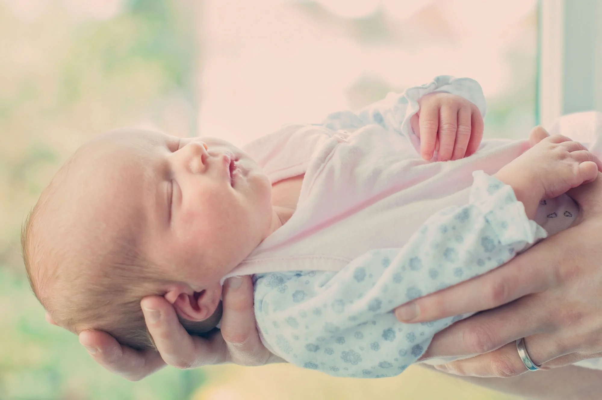 Newborn baby girl is held in her father's hands at their home in Highgate in north London