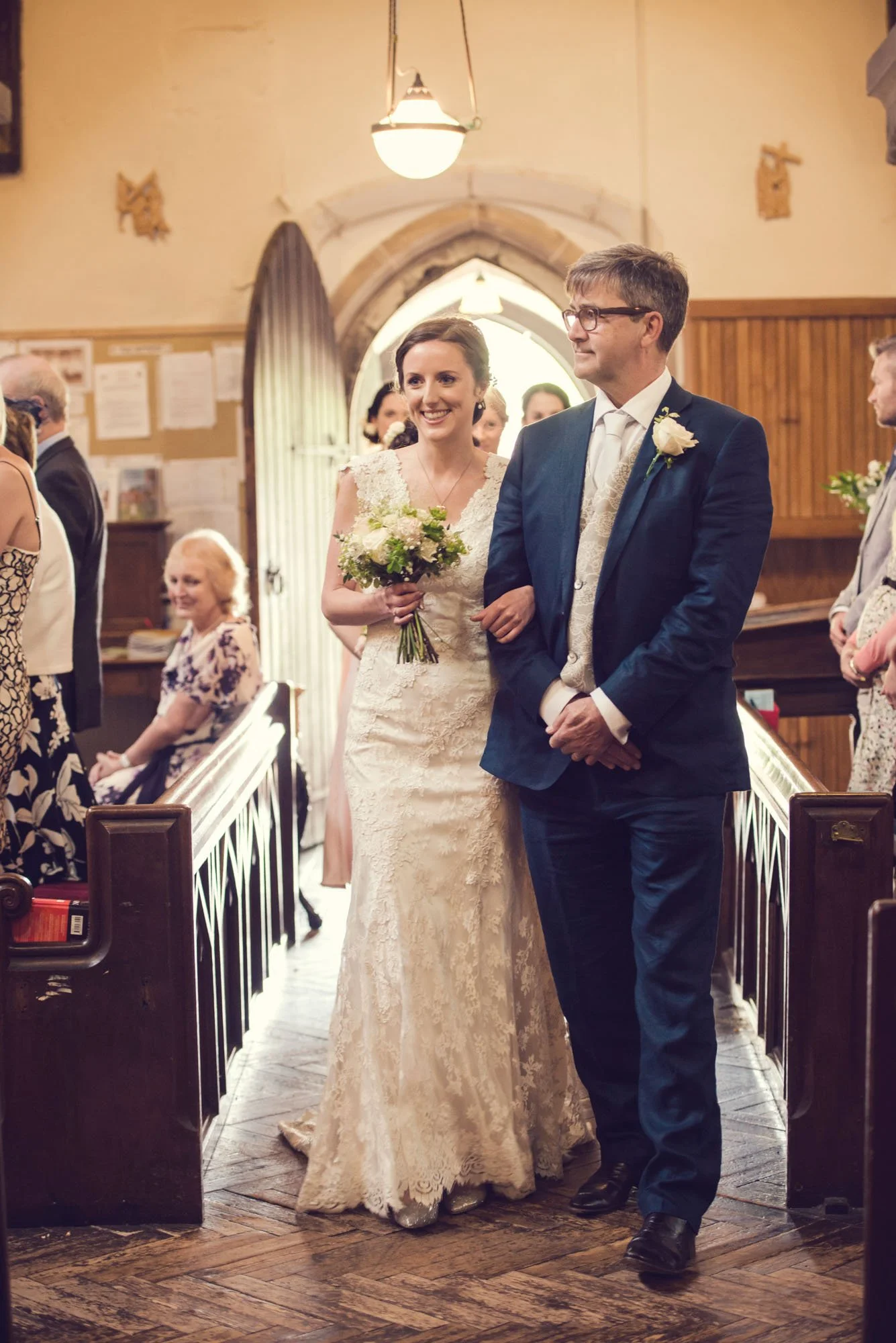 A proud father walks the bride up the aisle during a church wedding in Kent