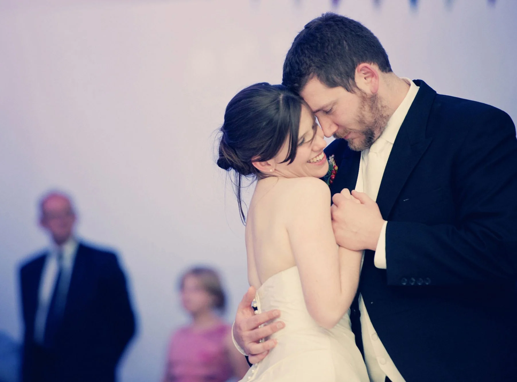 A groom hugs his bride to him during their first dance in a marquee at her parents' home in Clapham in south west London