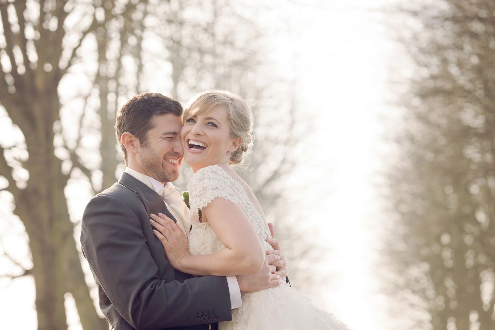 A groom lifts his laughing bride up as they celebrate after their weekday wedding at Islington Town Hall 