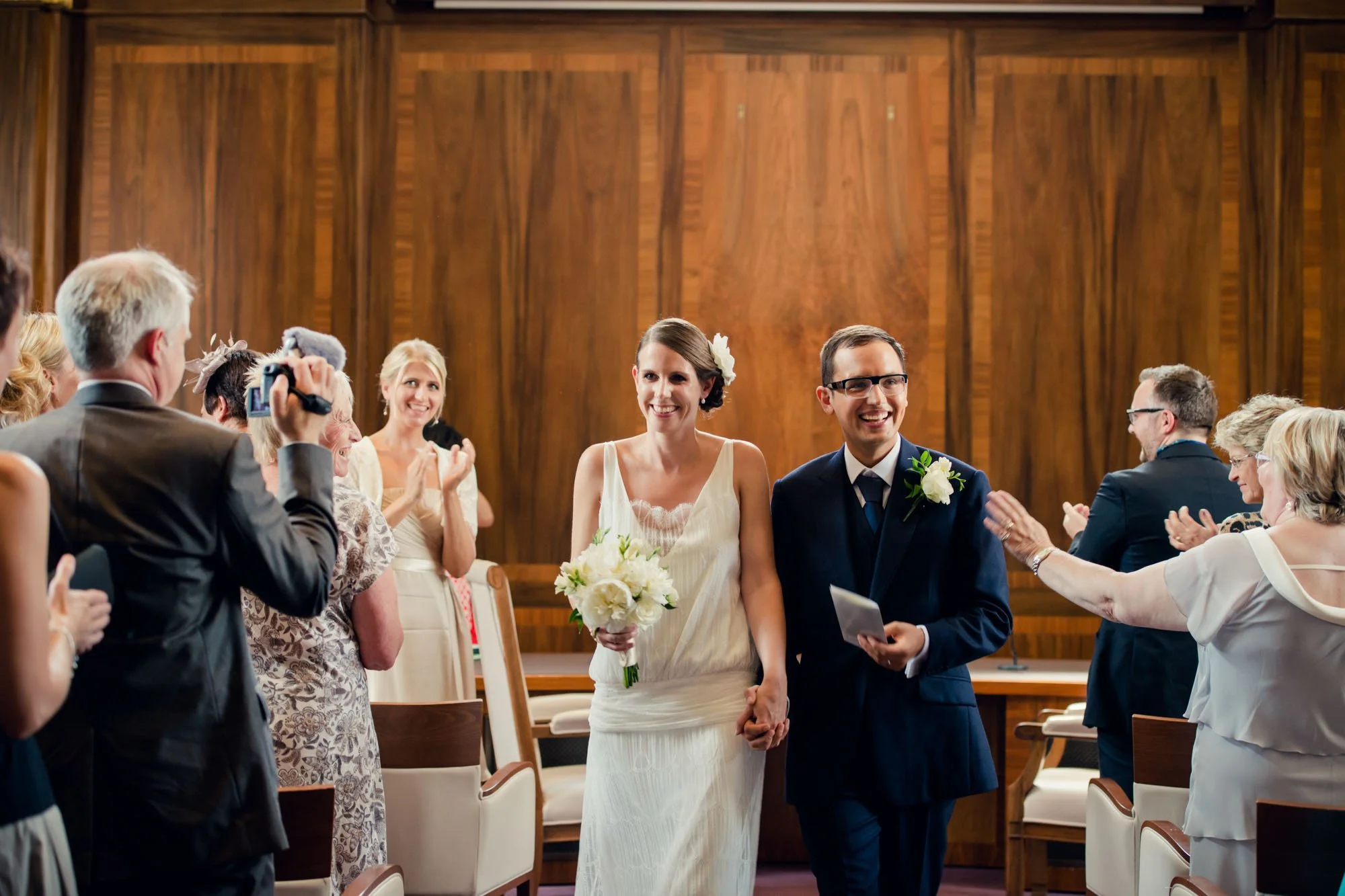 Bride and groom smiling at their guests after their micro wedding at Stoke Newington Town Hall in London