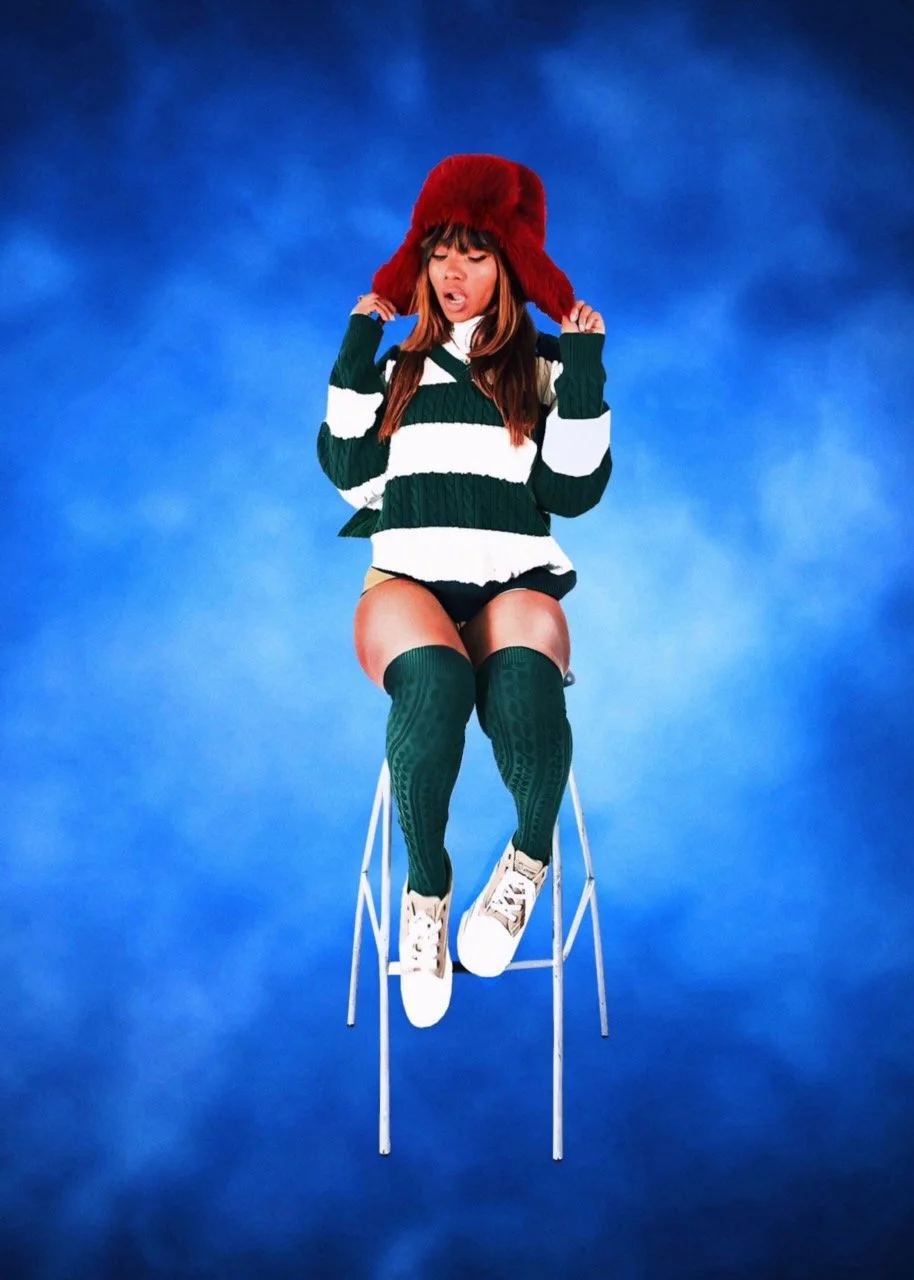 A woman sitting on a high stool wearing a red furry hat, a green and white striped sweater, green knee-high socks, white sneakers, with a blue cloudy background.