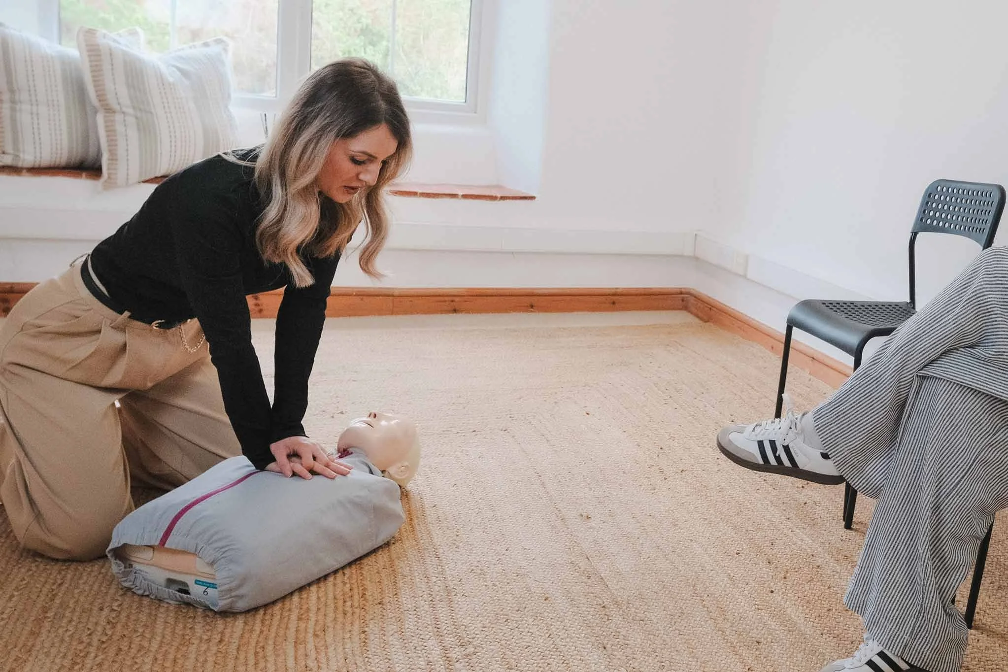 Chloe Child, founder of ADS Training and Amber Dental Staffing, demonstrates CPR on a dummy during a BLS training session in Towcester.