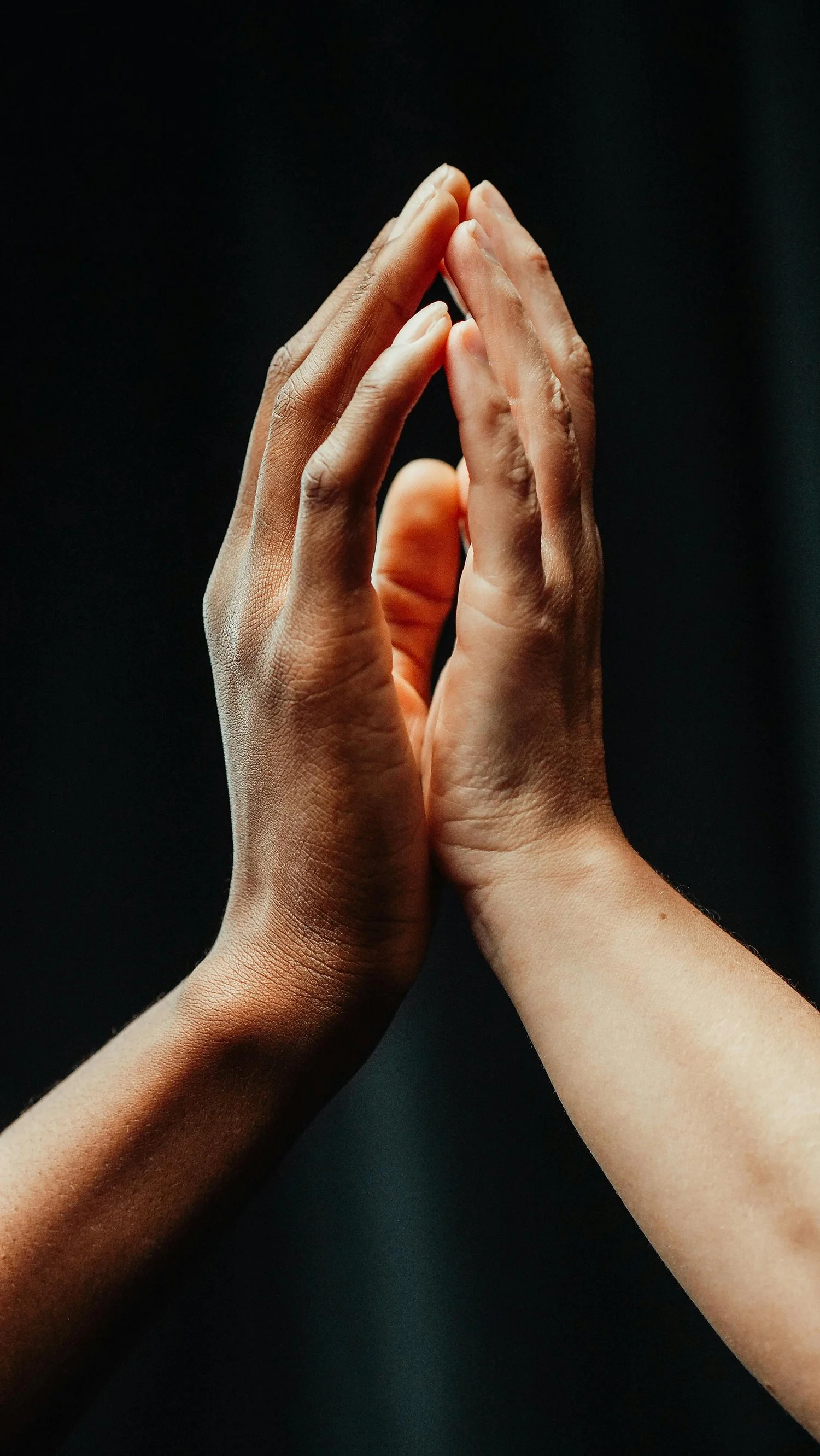 Two hands reaching toward each other, symbolizing connection, support, and human connection.