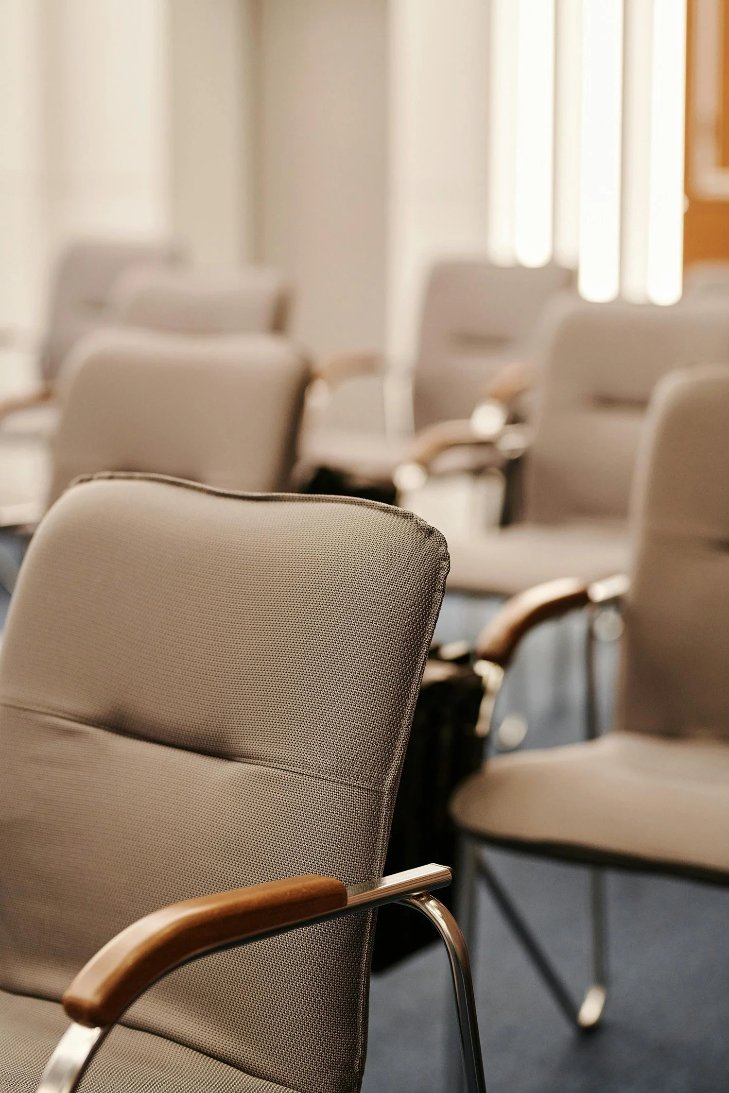 Empty chairs arranged in a quiet meeting room prepared for a group support or counseling session.