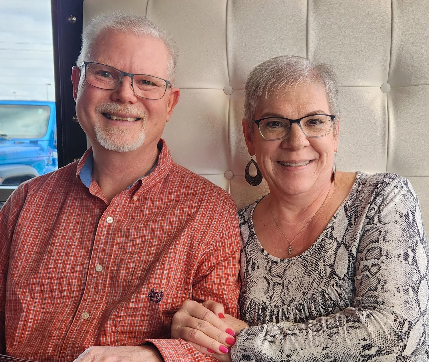 Kenny and Susan Smith smiling together while seated at a restaurant.
