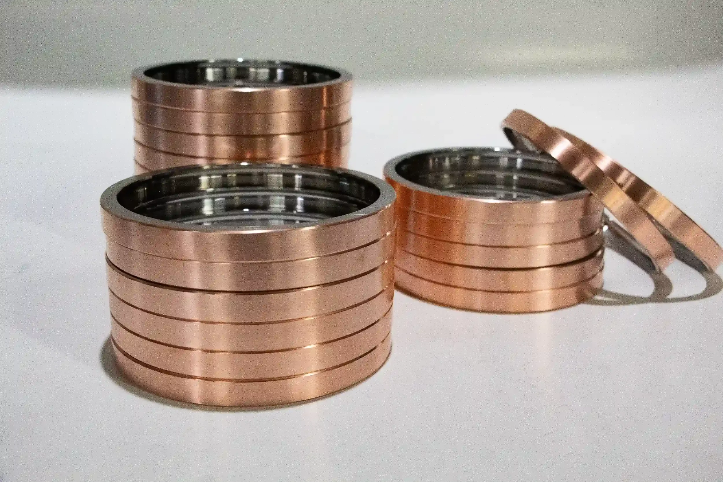 Stacks of copper-colored ball washers on a white surface.