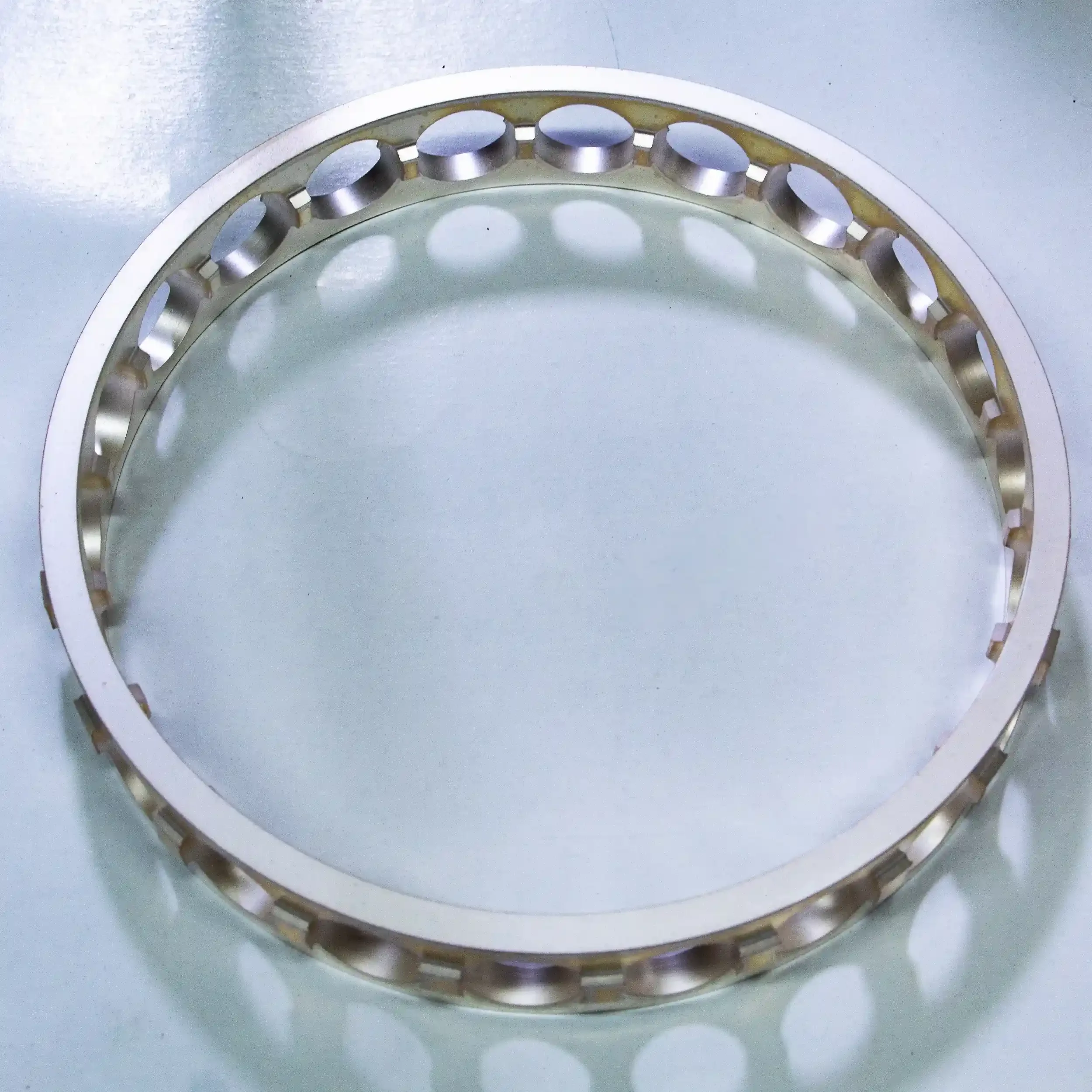 Close-up of a metallic washer with holes along the outside edge.