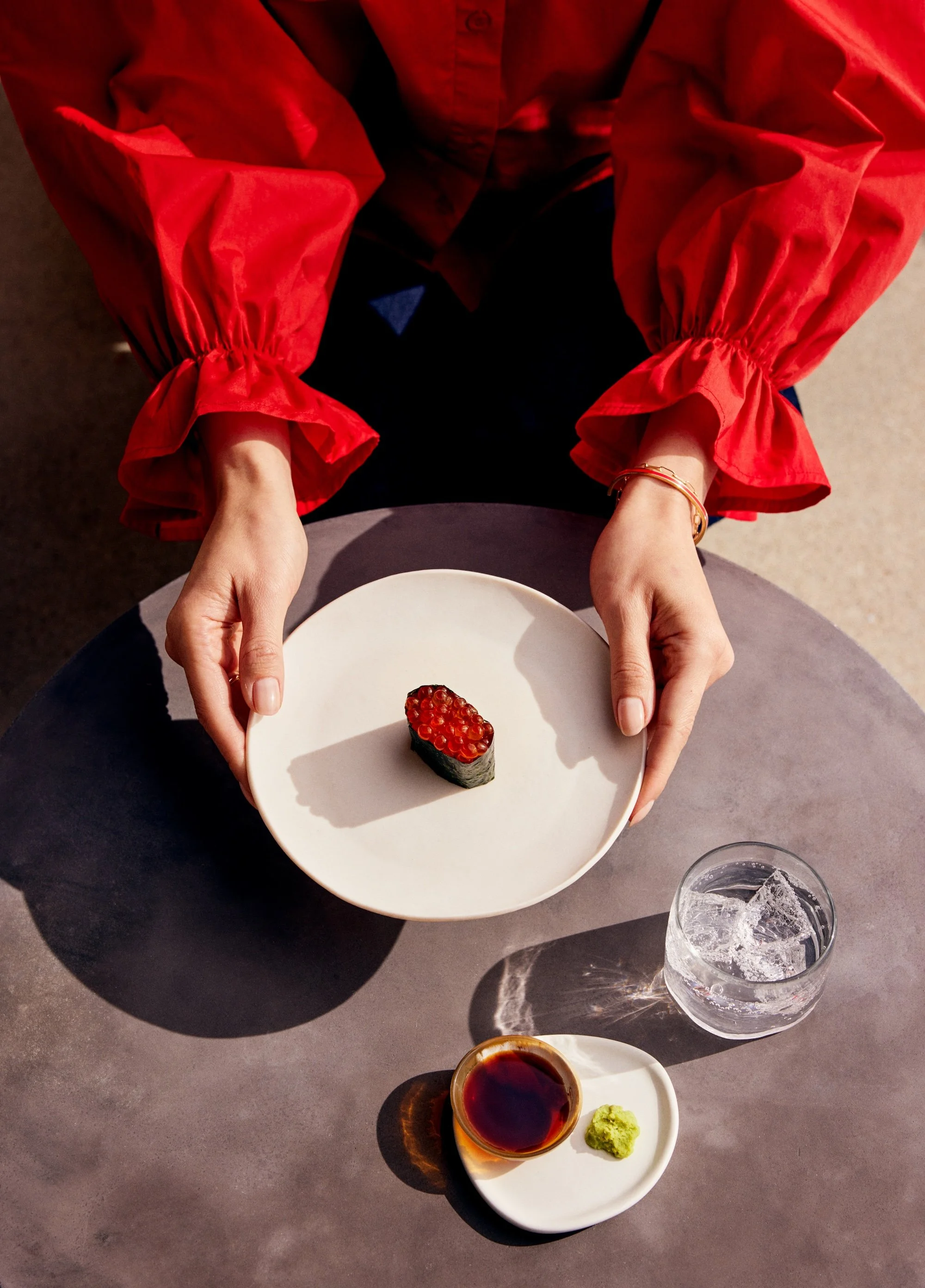 Person savoring a single piece of Hi.Dozo premium omakase nigiri