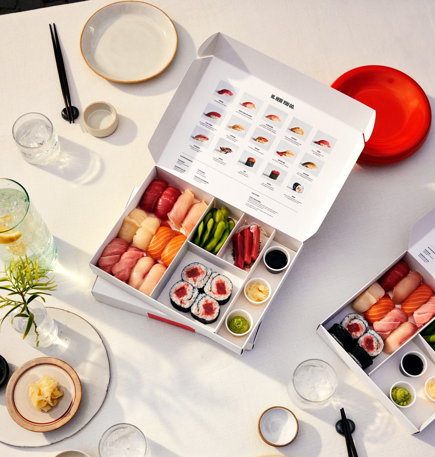 Hi.Dozo open omakase sushi delivery box with assorted nigiri and maki, overhead view