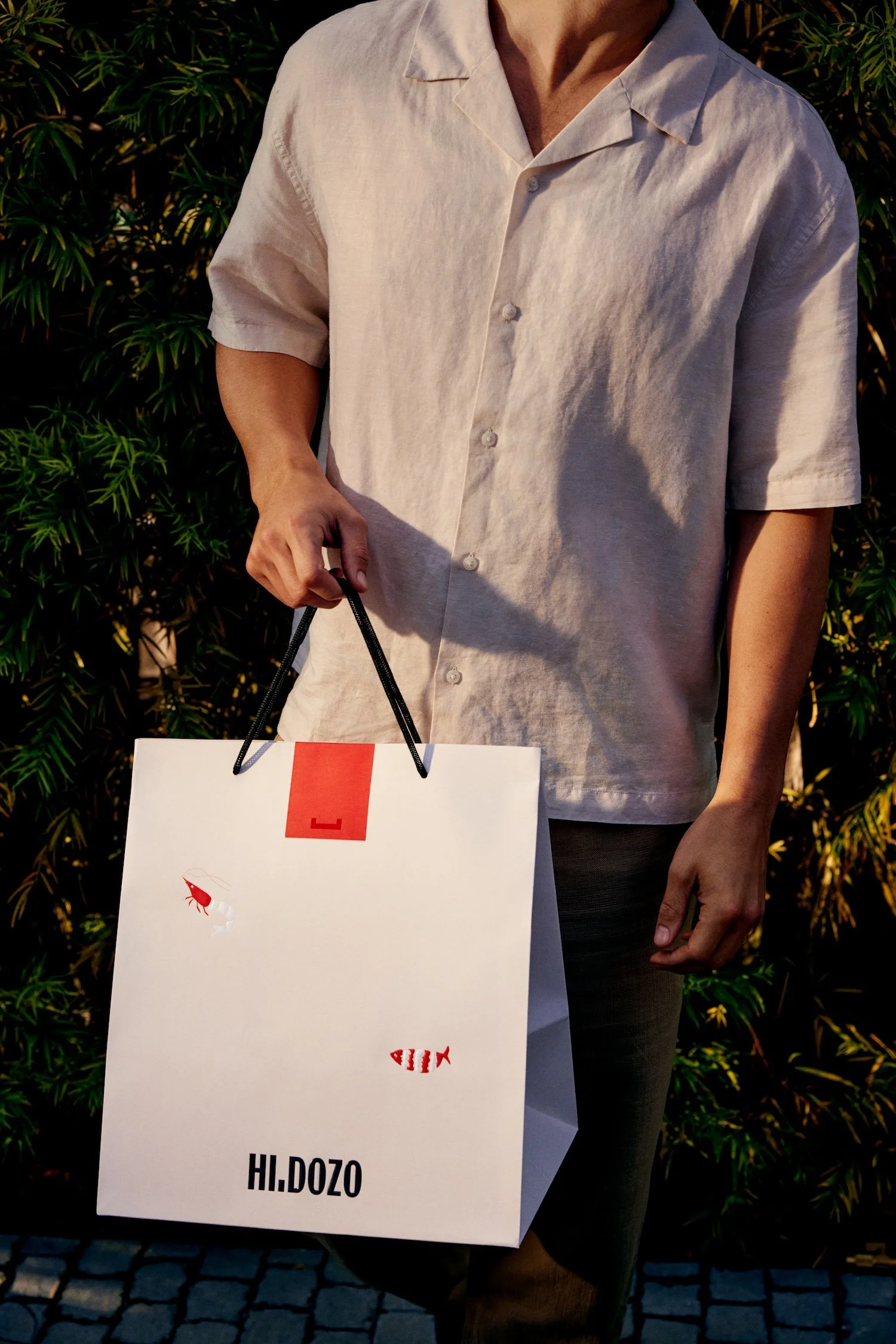 Hi.Dozo branded omakase delivery bag held by a customer in Los Angeles