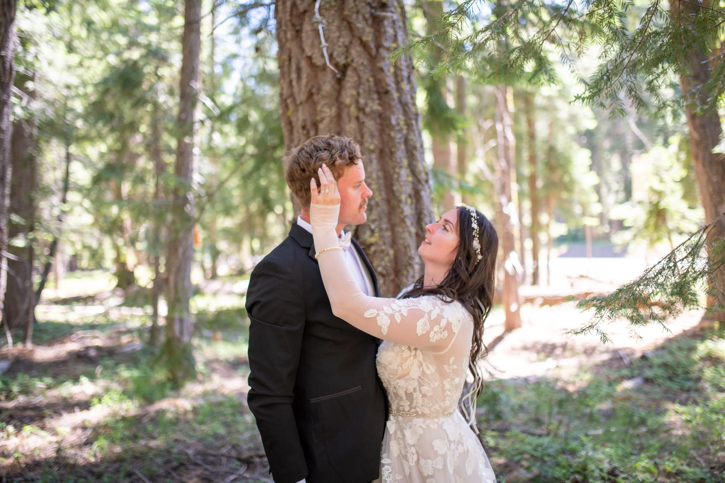 A bride and groom sharing a dance in a forest setting during their wedding.