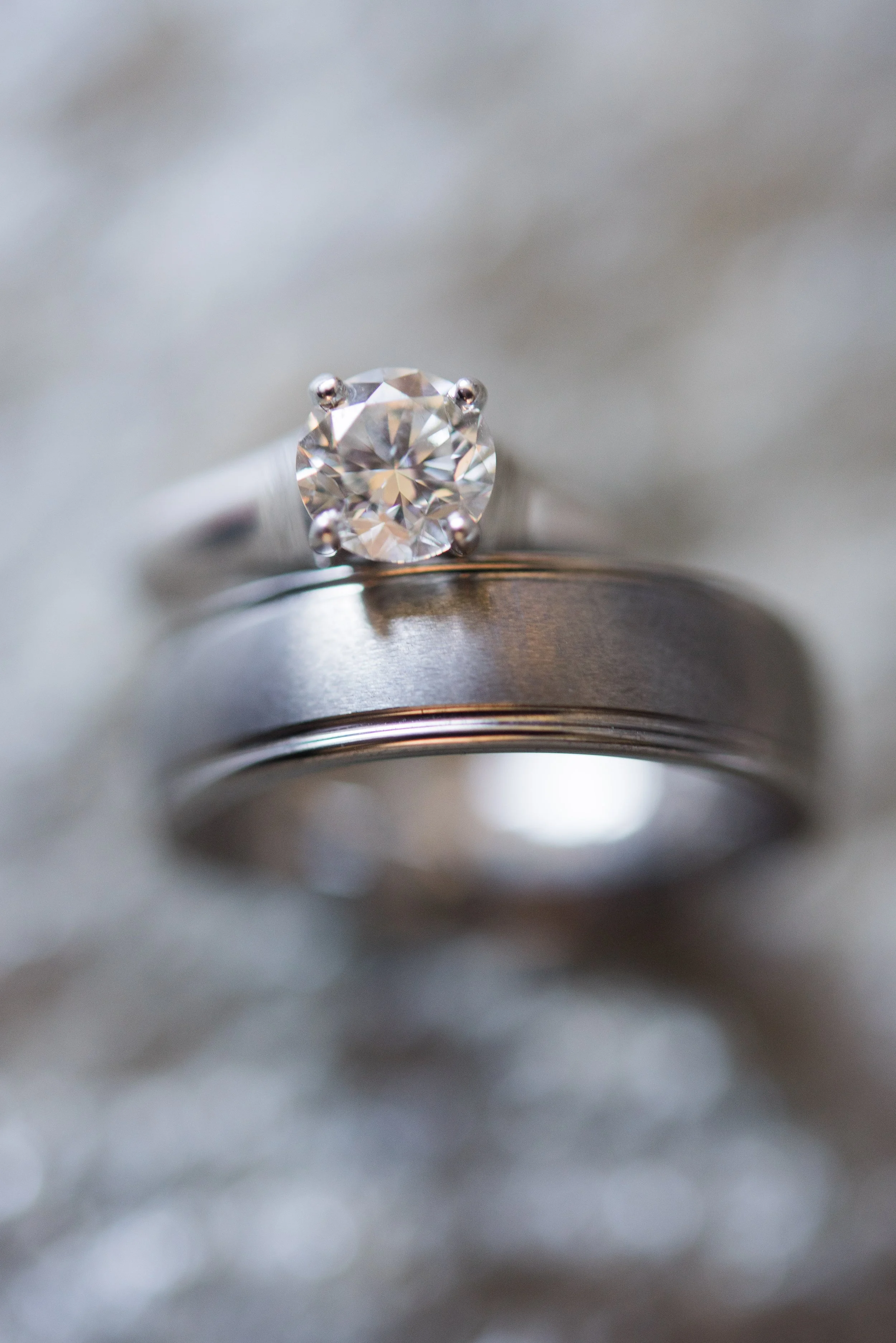 Close-up of a solitaire diamond ring with a large, round-cut diamond set in a four-prong setting on a silver band.
