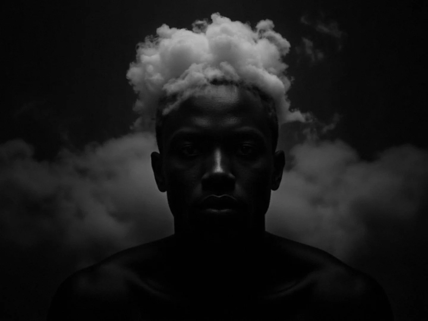 A black-and-white photo of a person's face with cloud formations resembling hair against a dark sky.