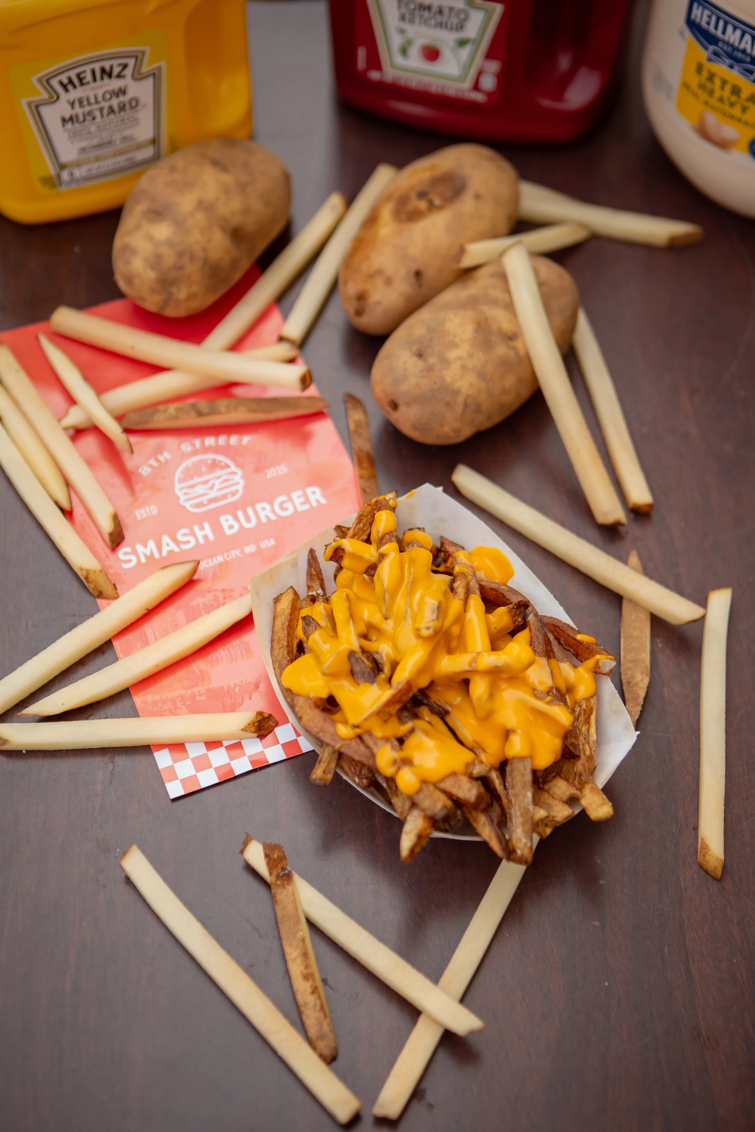 A tray of loaded French fries topped with melted cheddar cheese and crispy bacon bits.