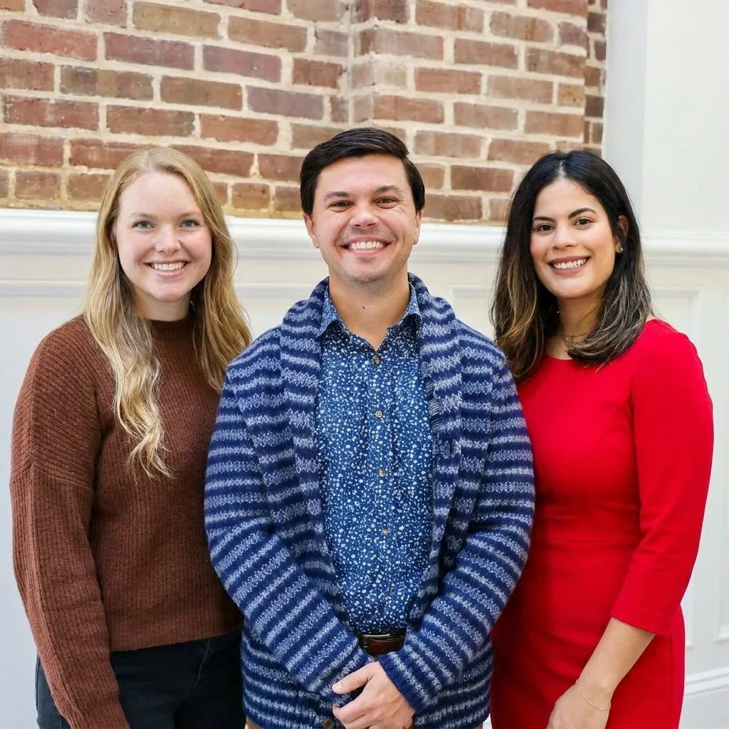 Therapists Jocelyn Peters, Steven Gilpin, and Liz Davila-Ferrall posing against a brick wall.