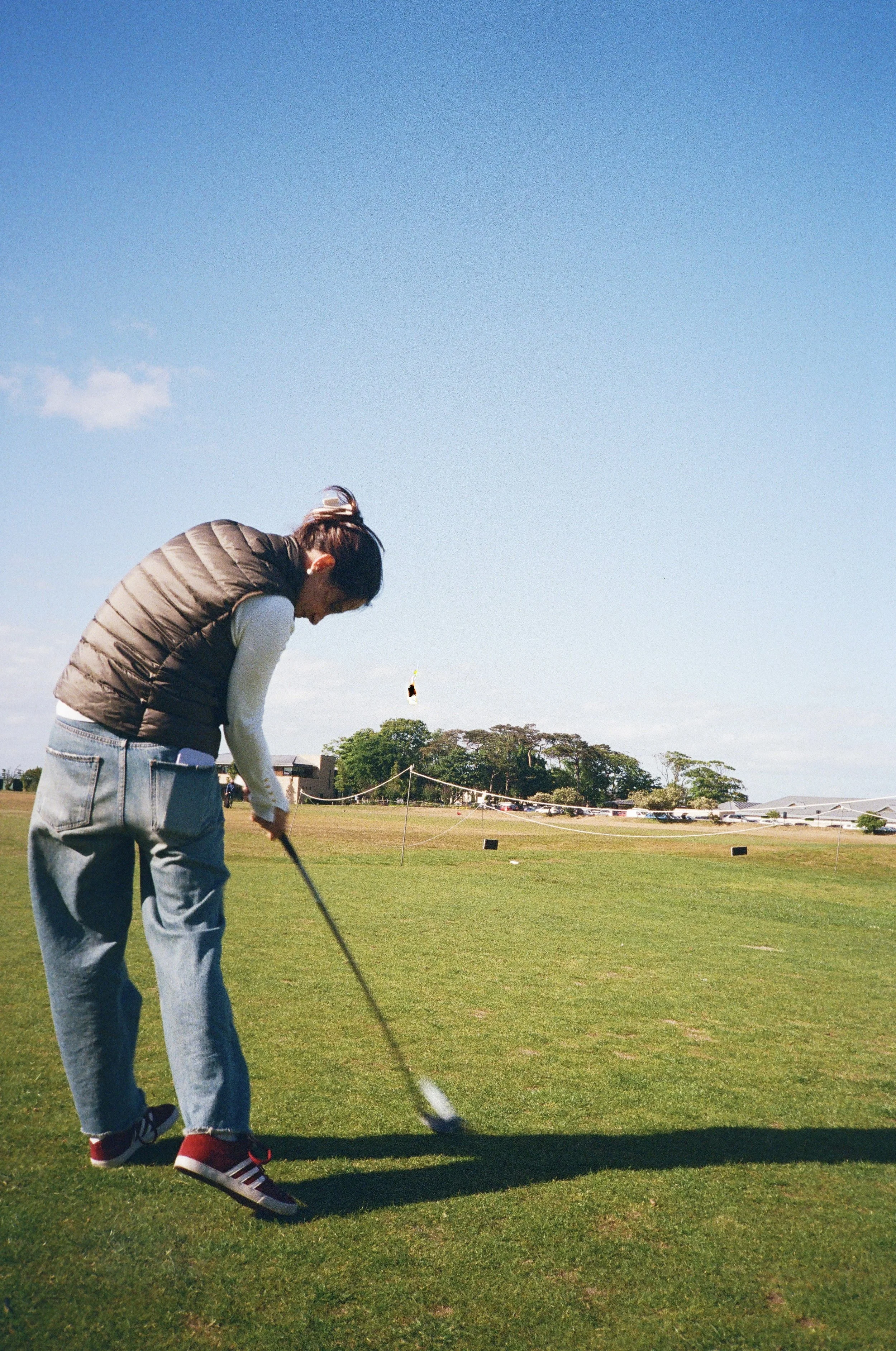 A person playing golf on a sunny day.
