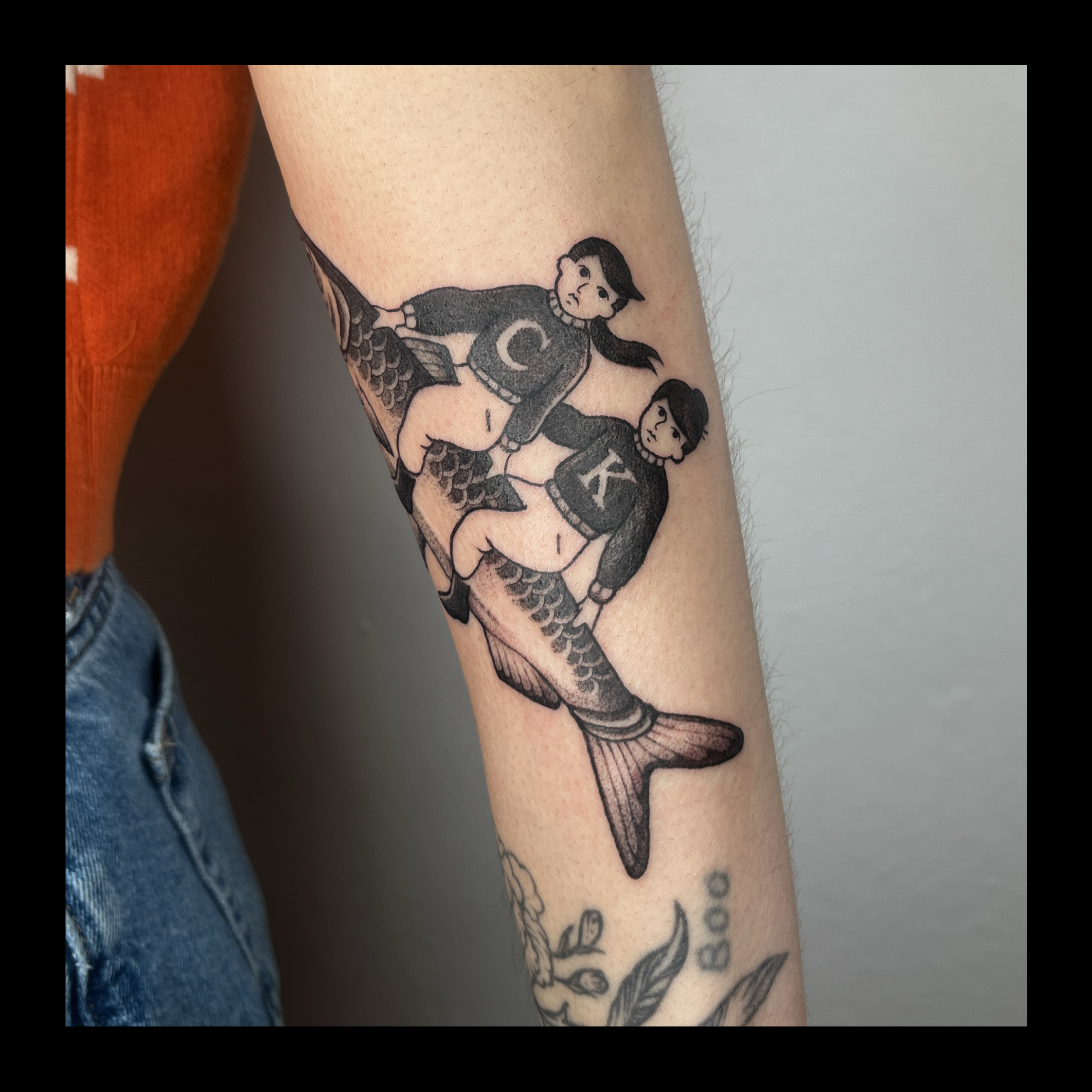 Black and grey tattoo of a girl with short hair, in a sailor outfit, on a person's arm.